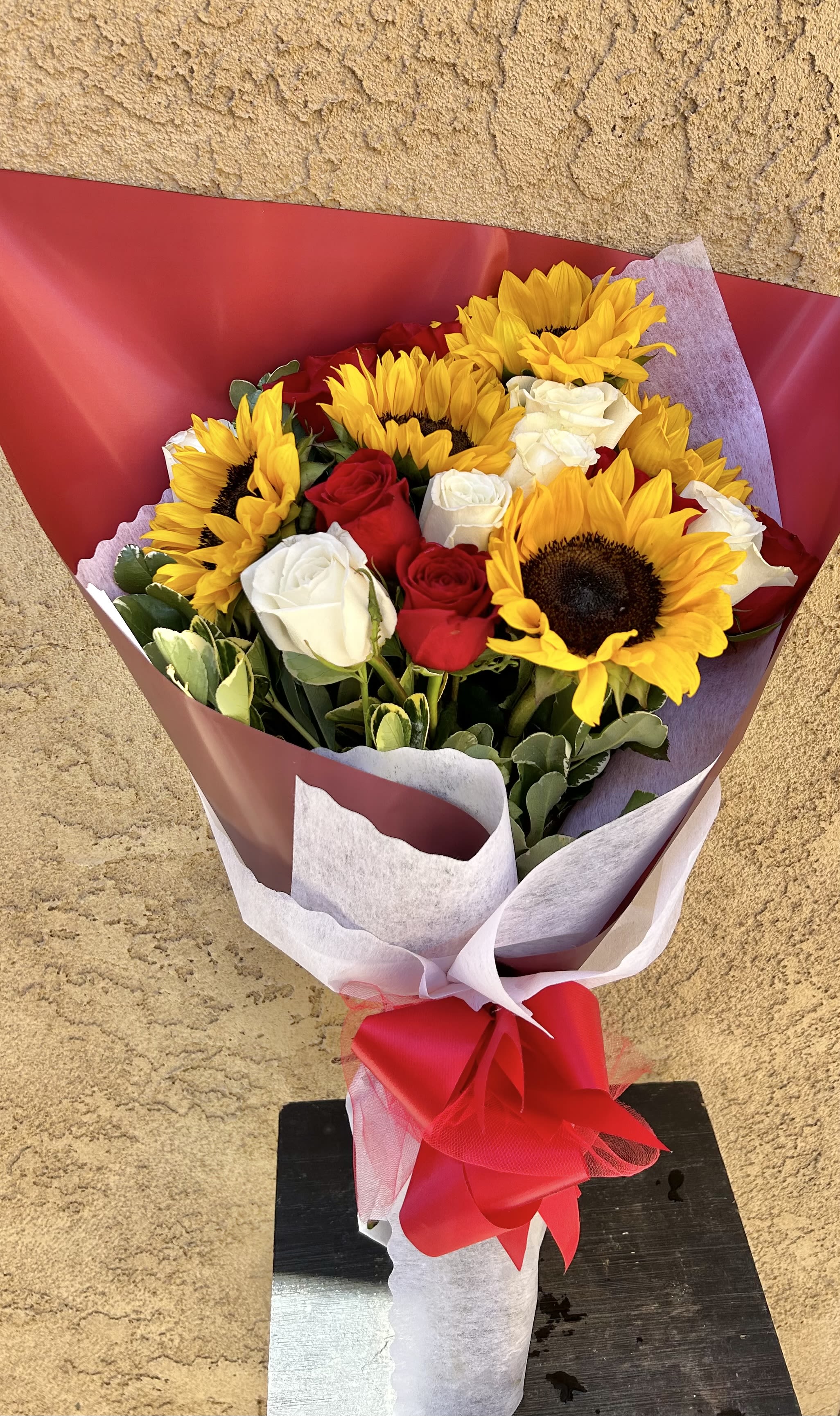 Wrapped in Joy - Beautiful bouquet of sunflowers, red and white roses, and green accents. 