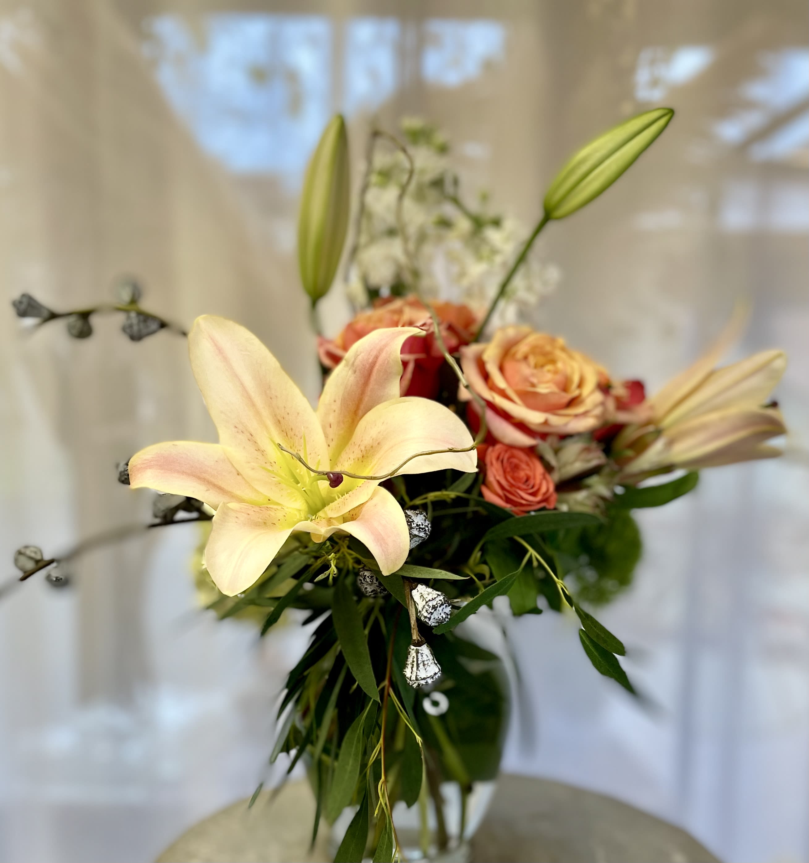 Modern Floribunda: Tangerine Dream Bouquet  Modern Floribunda: Tangerine Dream Bouquet  - Radiating the warmth of orange hues, this arrangement features blooms like roses, lilies, and alstroemeria in shades of apricot, tangerine, and coral. Arranged in a compact, leaf-wrapped vase, this vibrant bouquet embodies energy and creativity, perfect for celebrations or uplifting any space.