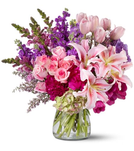 Royal Radiance - Royal Radiance is a breathtakingly dramatic bouquet designed to leave a lasting impression. Featuring a luxurious mix of pink and purple blooms, including roses, peonies, lilies, tulips, snapdragons, and hydrangeas, this grand arrangement exudes elegance and charm. Artfully arranged in a clear glass hurricane vase, it’s the perfect gift for making unforgettable memories.