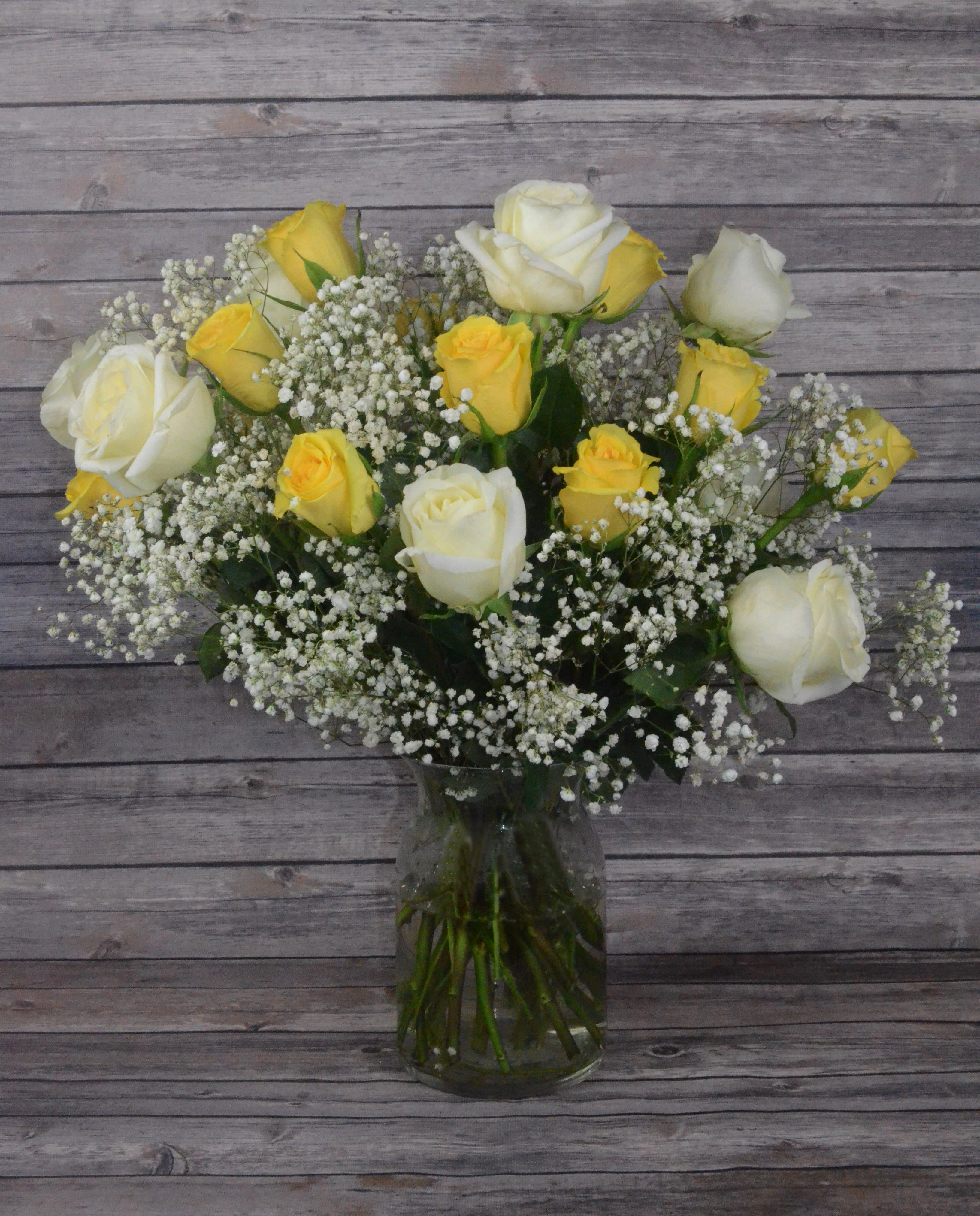 Spirit of Happiness - Spread joy all around with this blend of yellow and white roses. All bouquets are arranged by our professional floral design team accented with seasonal filler (i.e. greenery, baby’s breath, etc.) inside an elegant glass vase or gift box. Blooms are hand delivered in person to enhance any celebration or a “just because” surprise. Our team selects the freshest flowers available, so shade of rose may vary due to seasonal availability. When artistically designed in a clear glass vase arrangement measures approximately 23&quot;H x 18&quot;L.
