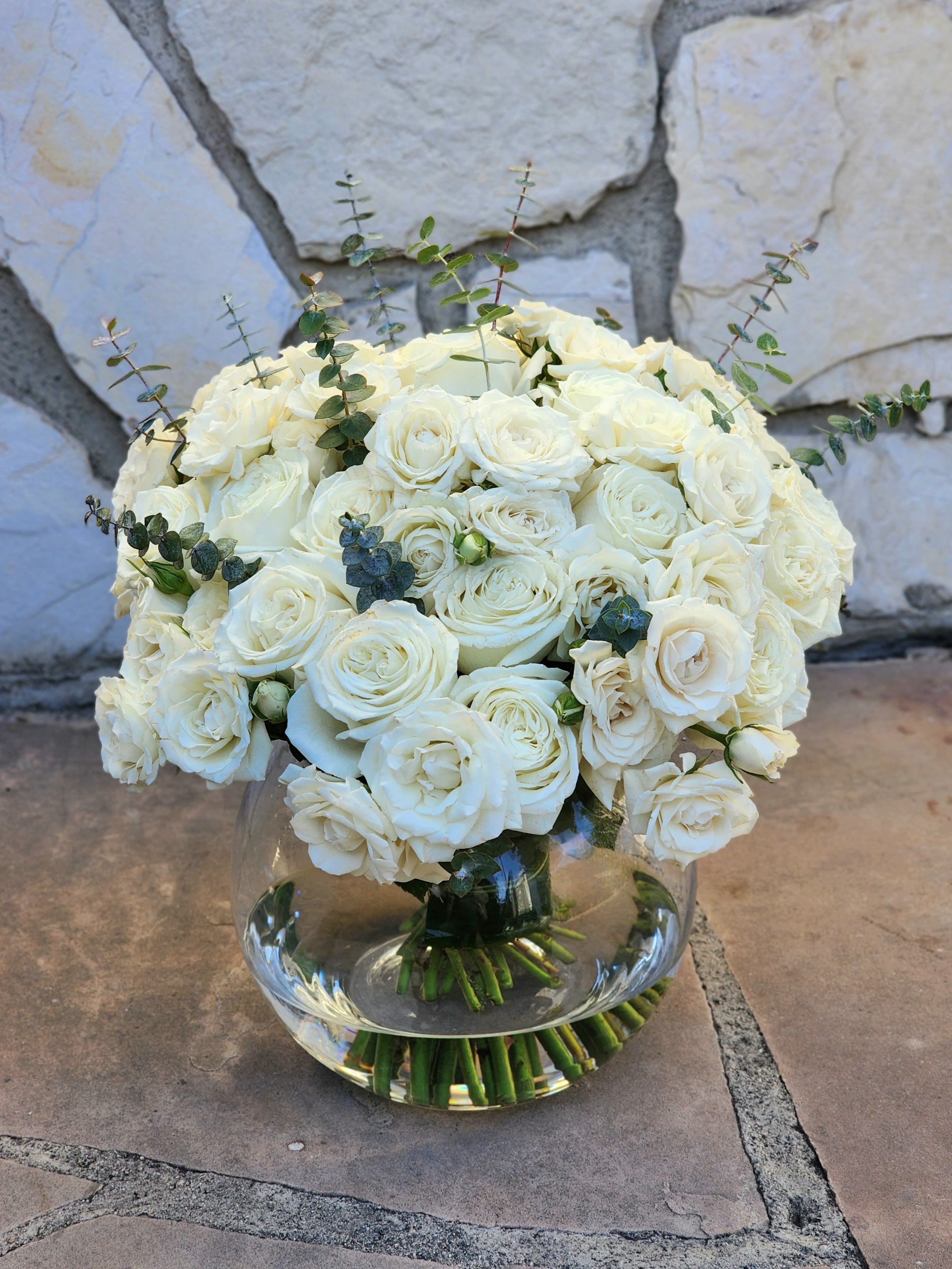 The Perfect Way - Looking for the perfect way to add a touch of elegance to your day? This stunning white rose arrangement, accented with eucalyptus, is designed to bring timeless beauty into any space