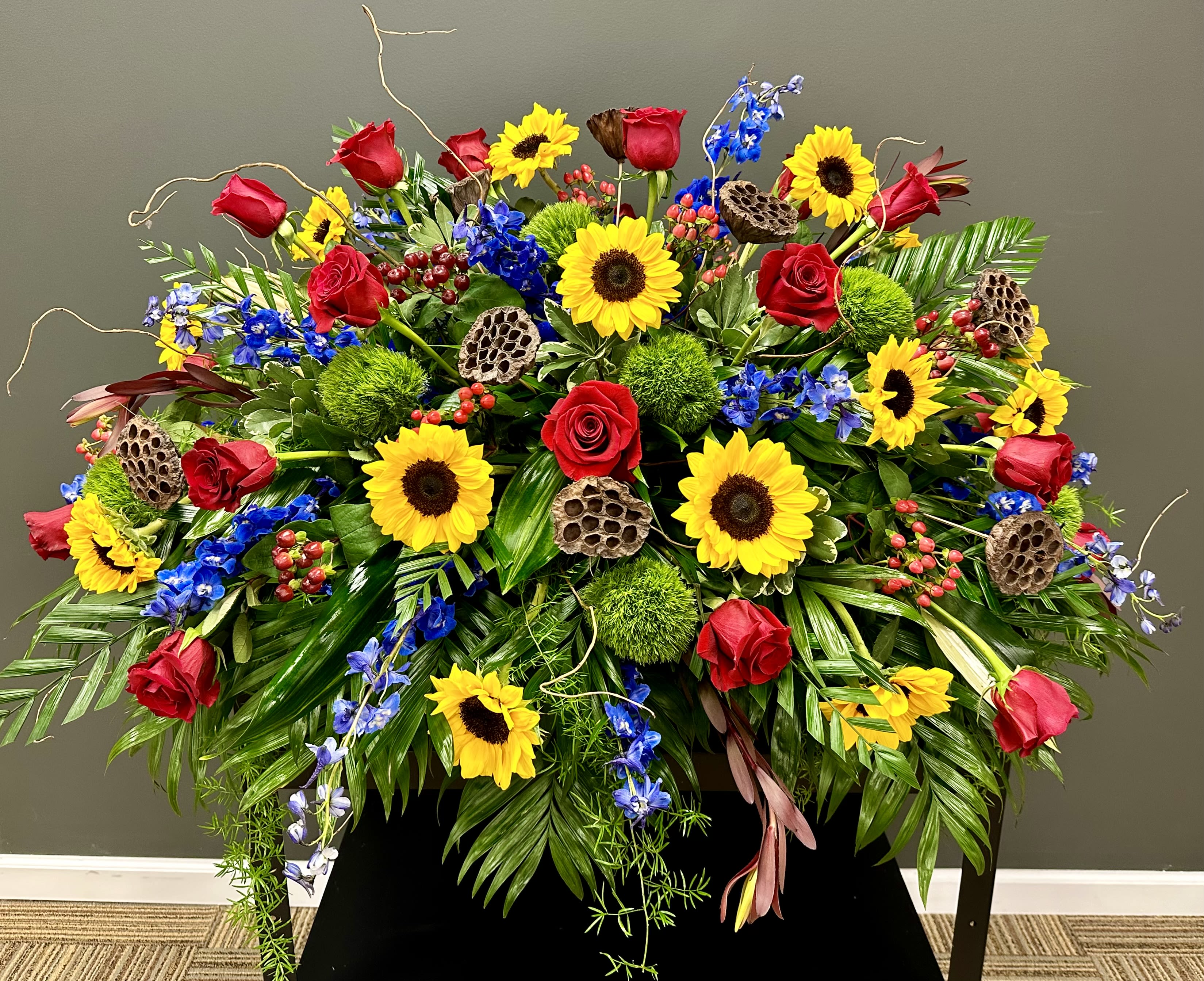 Red rose and sunflower casket spray in McKenzie, TN | Petals