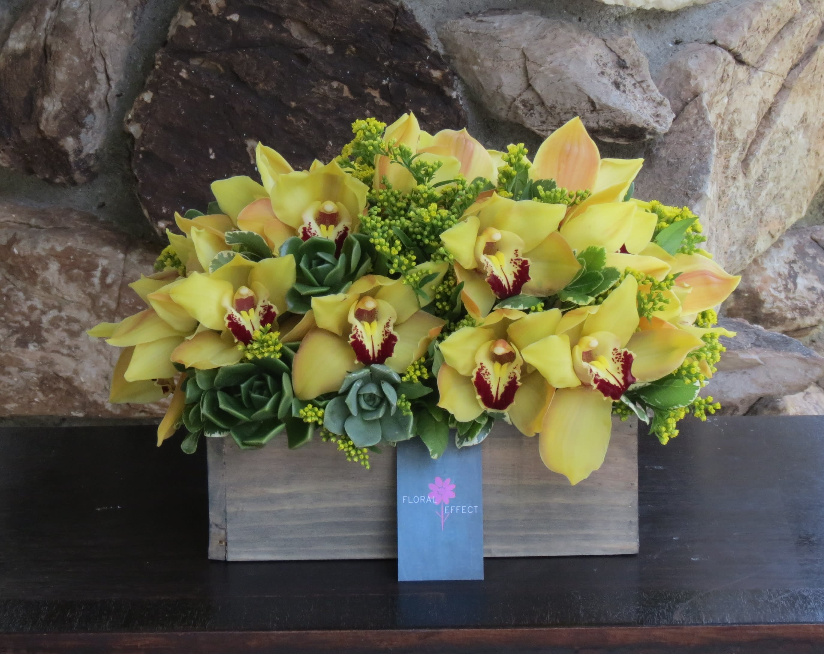 Yellow cymbidiums and succulents Yellow cymbidiums and succulents - yellow cymbidiums and succulents arranged on a wood box