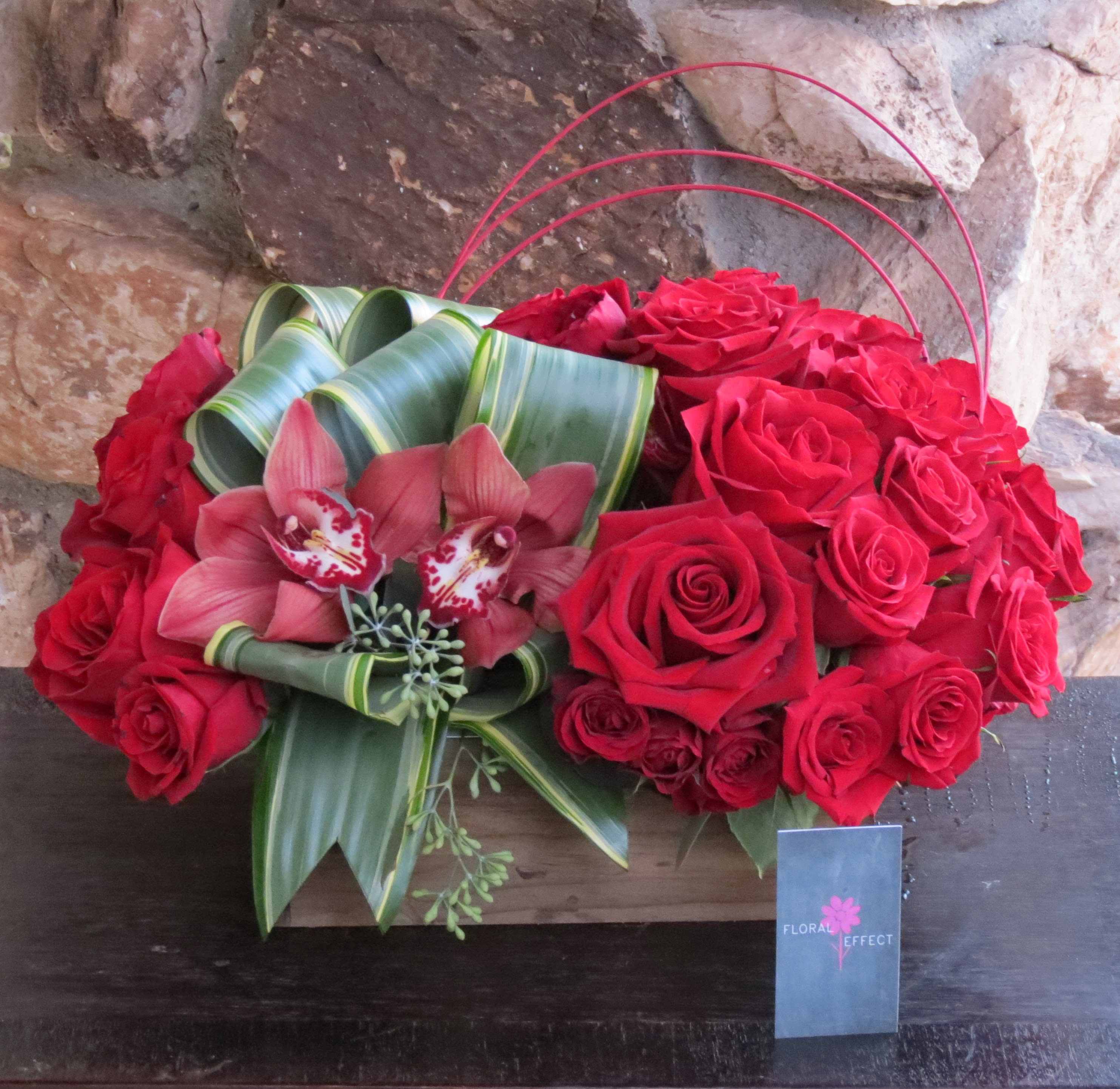 Red roses and cymbidiums on a box Red roses and cymbidiums on a box - Beautiful red roses and red cymbidiums arranged on a wood box