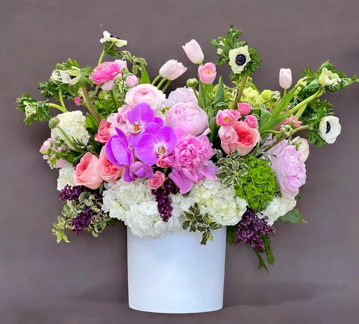 Luna de miel - This elegant and posh garden arrangement sits regally in a beautiful white ceramic vase. A grandiose gift for yourself or your loved one!  vase size: 10x9in  *blooms and vase subject to availability*