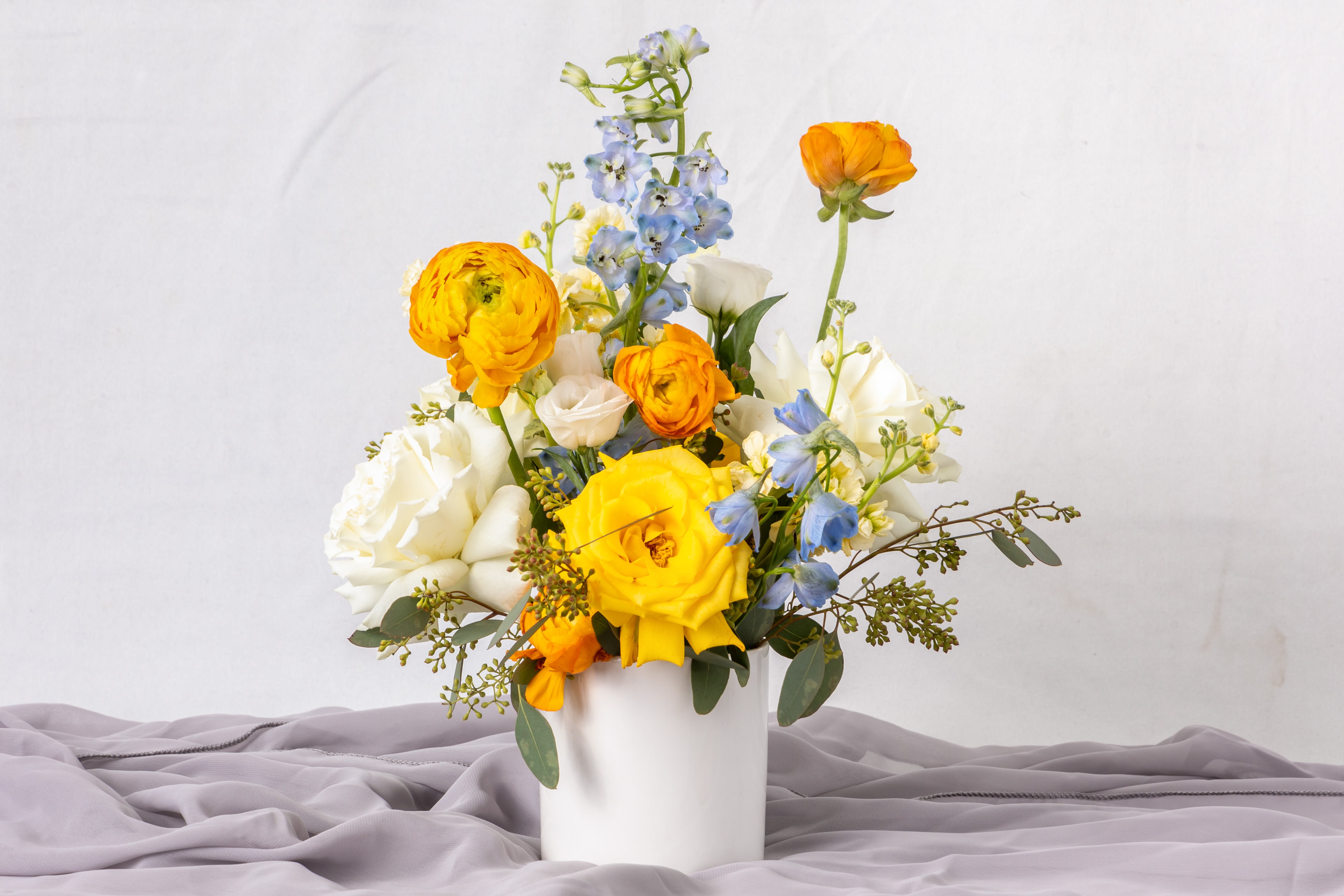 Morning Sky - Yellow, white, and blue floral arrangements evoke a sense of brightness, tranquility, and freshness. The vibrant yellow adds warmth and energy, the white brings purity and balance, and the blue offers a calming touch. Together, they create a harmonious and uplifting design, perfect for celebrations, special occasions, or as a thoughtful gift to convey peace and joy.
