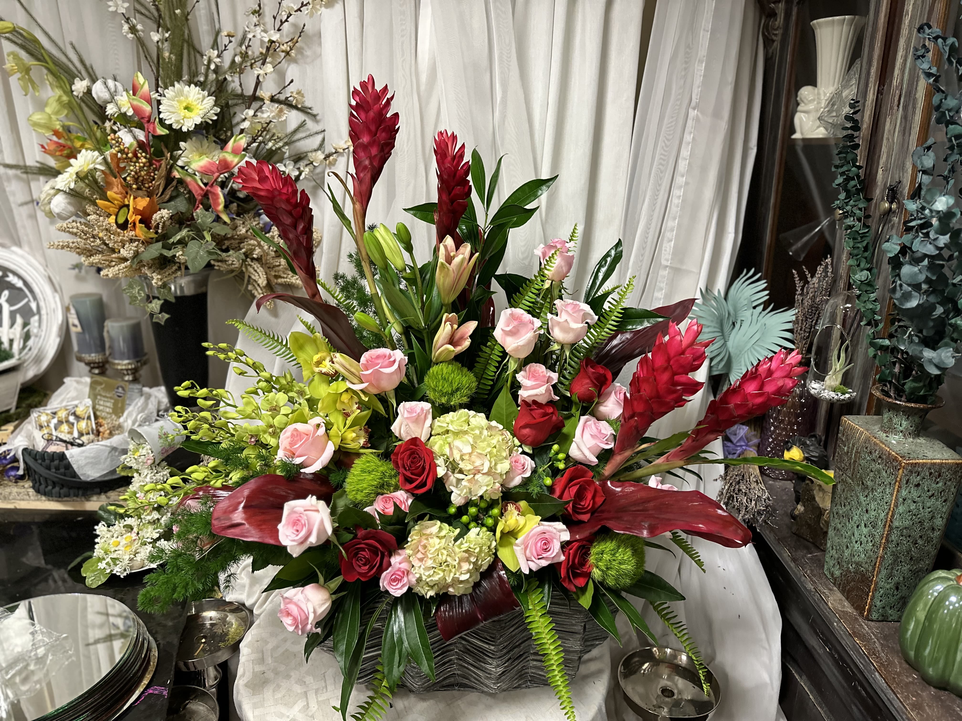Tropical Grandeur - Make an unforgettable statement this Valentine’s Day with Tropical Grandeur, a lavish and oversized masterpiece of exotic beauty. This luxury arrangement features striking red ginger, velvety red and pink roses, and lush tropical foliage for a breathtaking display of passion and sophistication. Perfectly designed for those who want to go above and beyond, Tropical Grandeur captures the essence of love in full bloom.  Dramatic, bold, and utterly unique, this show-stopping arrangement is the ultimate way to express your deepest emotions. Order now and deliver a Valentine’s Day gift they’ll never forget.  Go big. Go bold. Go unforgettable.