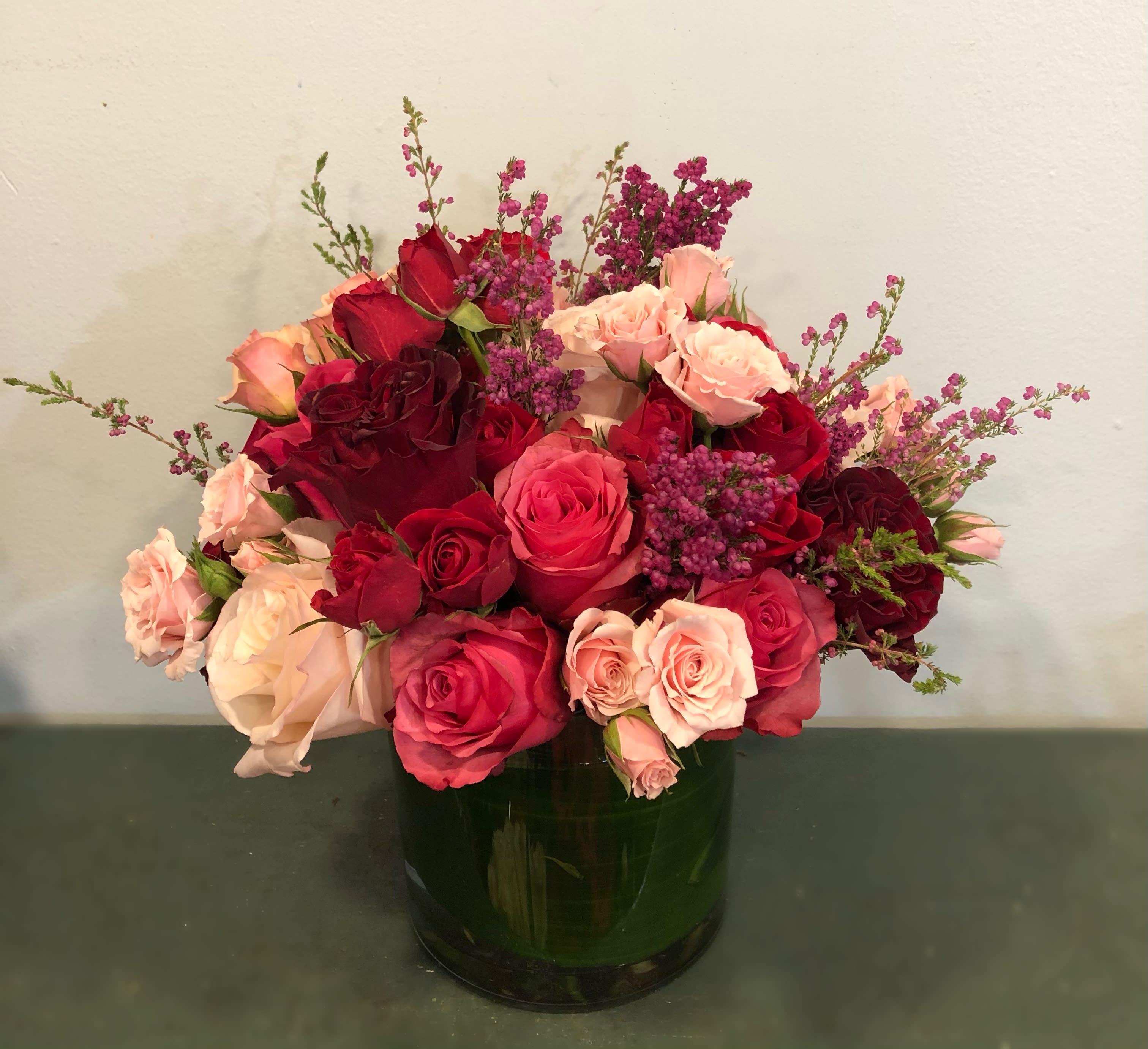 English Rose Garden English Rose Garden - If roses are a favorite this design is for you. Carefully selected roses in a beautiful glass vase lined with green leaf awaits for that someone special. Colors may vary depending on availability.