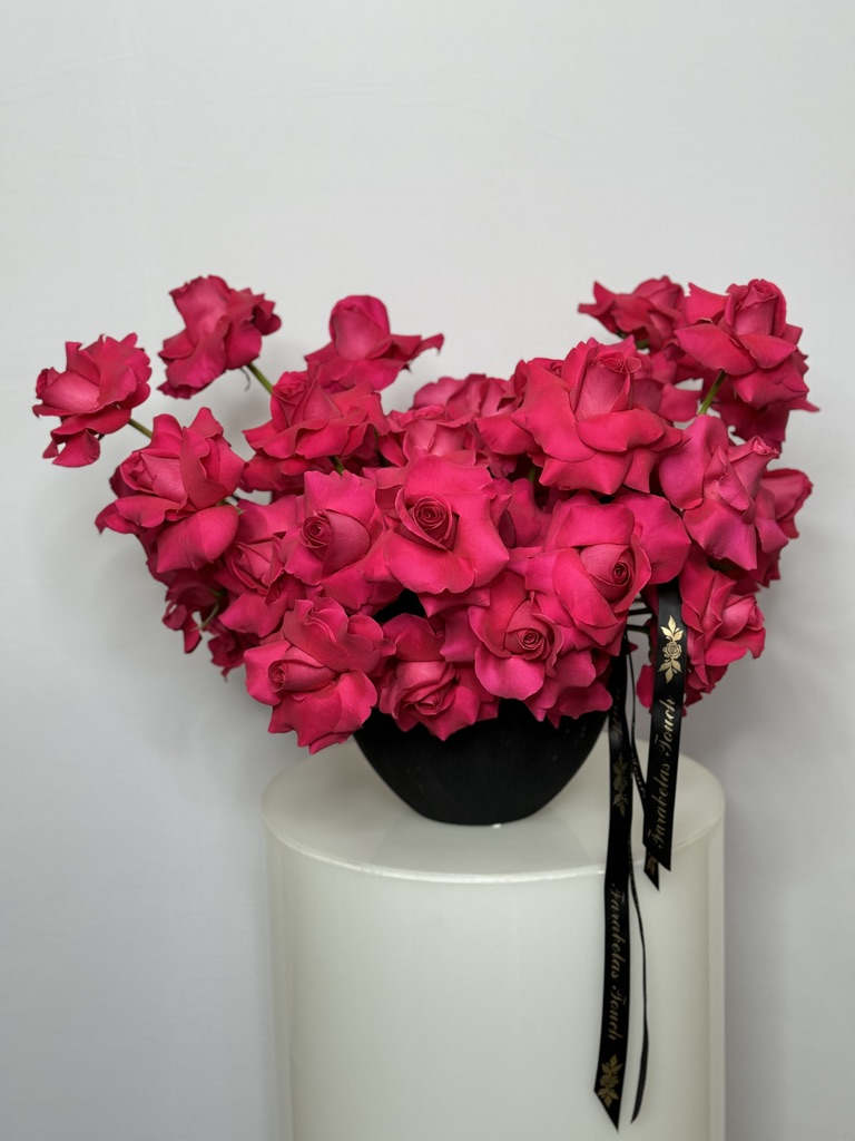Sexy Pink - The modern style arrangement in the black vase is an exquisite display of elegance and sophistication. The volume of roses creates a harmonious color that is both eye-catching and romantic.  This arrangement is carefully designed to convey a sense of modern beauty, blending contemporary elements with timeless floral charm. Whether placed in a home or used as a centerpiece for a special occasion, this arrangement is sure to captivate and delight all who admire it. Great choice as a centerpiece for baby showers, for birthdays and any other occasion. 