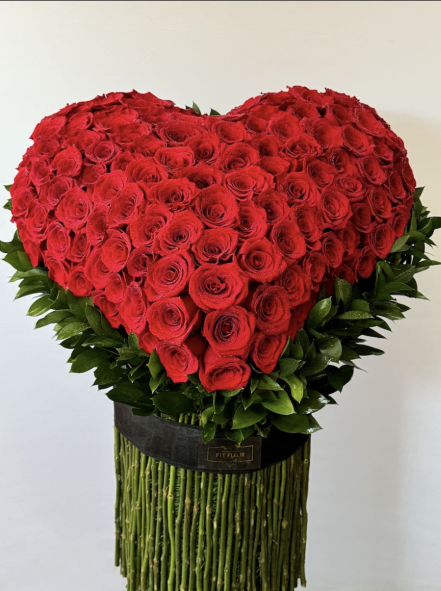 Red Heart Vase of Affection  - Send someone this soulful floral gift and there'll be no mistaking that you're giving them your heart! A heart made entirely of long red roses is nestled in a cloud of  greenery and presented with a pretty ribbon. Introducing the **Red Heart Vase of Affection**, a stunning hand-standing self-arrangement that beautifully captures the essence of love. Each rose is meticulously handcrafted and thoughtfully placed to form a heart shape, creating a striking visual that is both a statement piece and a heartfelt expression of your feelings. Designed by our talented floral artisans, this one-of-a-kind arrangement showcases the meticulous attention to detail and artistry that goes into every bloom. Perfect for anniversaries, romantic gestures, or simply to show someone you care, the **Red Heart Vase of Affection** is a timeless gift that embodies deep affection and warmth. Let this exquisite arrangement convey your love in a truly unforgettable way.