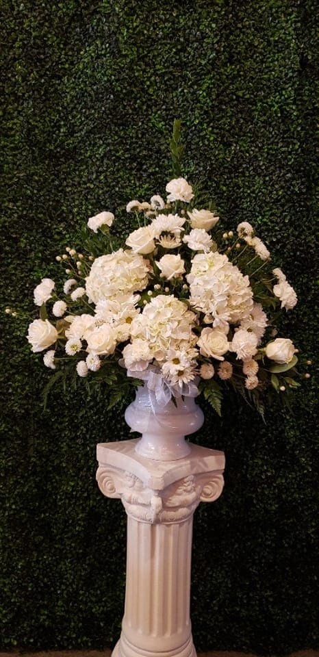 Elegant Tribute - White blooms of designer's choice designed into a one sided spray. Traditionally for a memorial of a loved one.