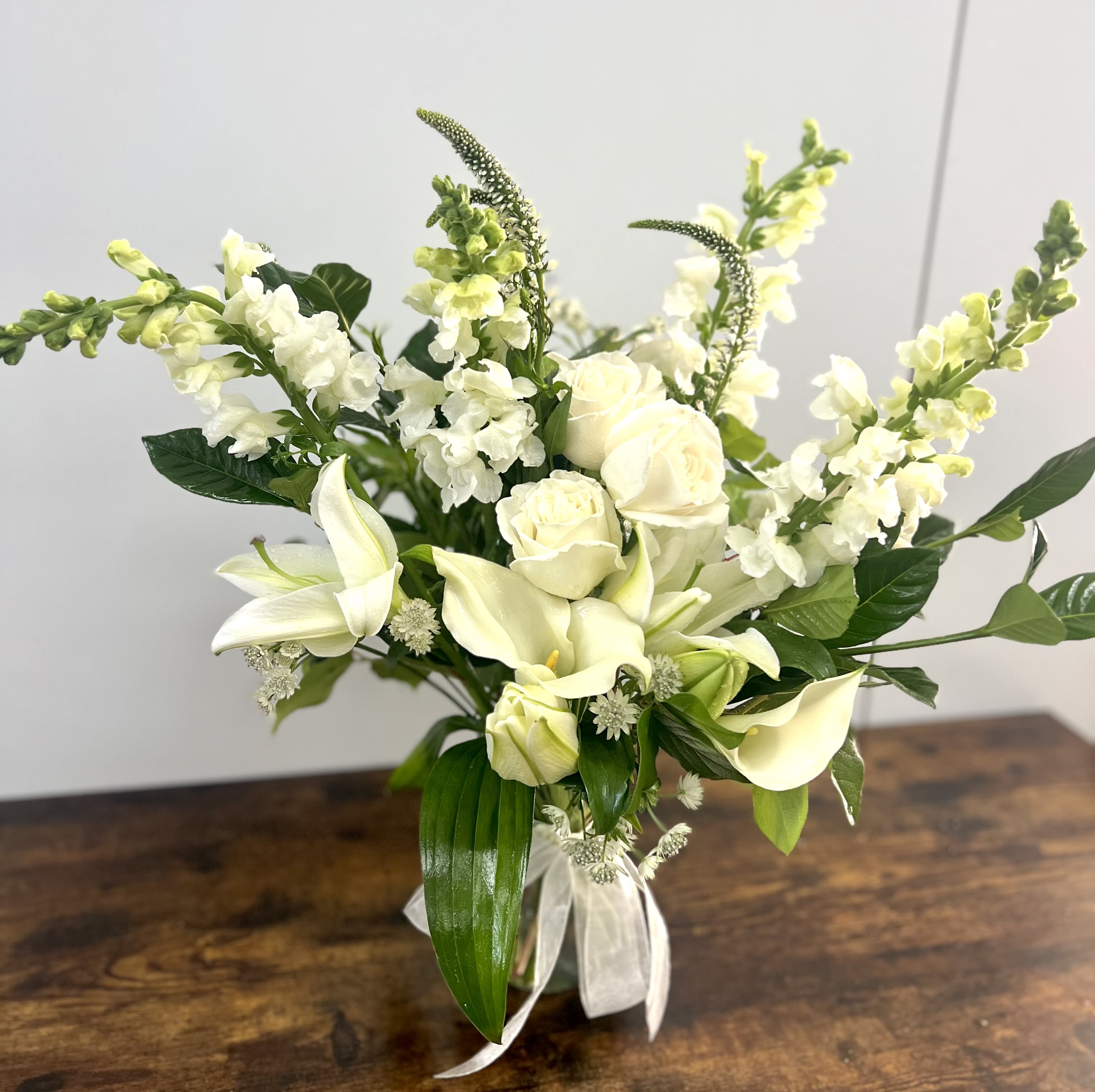 Purity - Pretty design including rose, lily, snapdragon and accents in a glass vase.