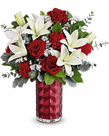 Floral Harmony Bouquet Floral Harmony Bouquet - This Valentine's Day floral arrangement is a breathtaking combination of classic romance and elegant contrast. It features white lilies, deep red roses ,and rich red carnations that add texture and vibrancy. Small clusters of white statice flowers, along with soft dusty miller leaves and sprigs of eucalyptus, provide a delicate touch. The arrangement is set in a striking deep red glass vase with a textured, faceted design, enhancing its sophisticated and luxurious appeal. This bouquet is a perfect expression of love, making it an ideal gift for Valentine's Day.