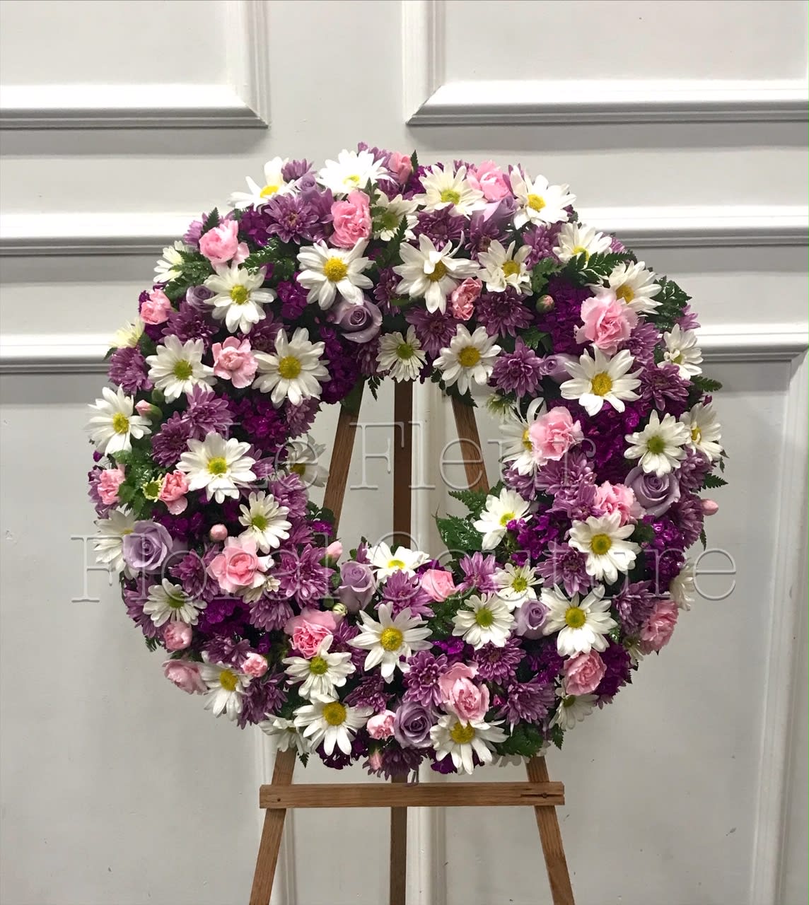 Gentle Gift Sympathy Wreath Gentle Gift Sympathy Wreath - A modest design of white daisies, lavender cushion pompom, plum pompom, light pink mini carnations, ocean song roses.