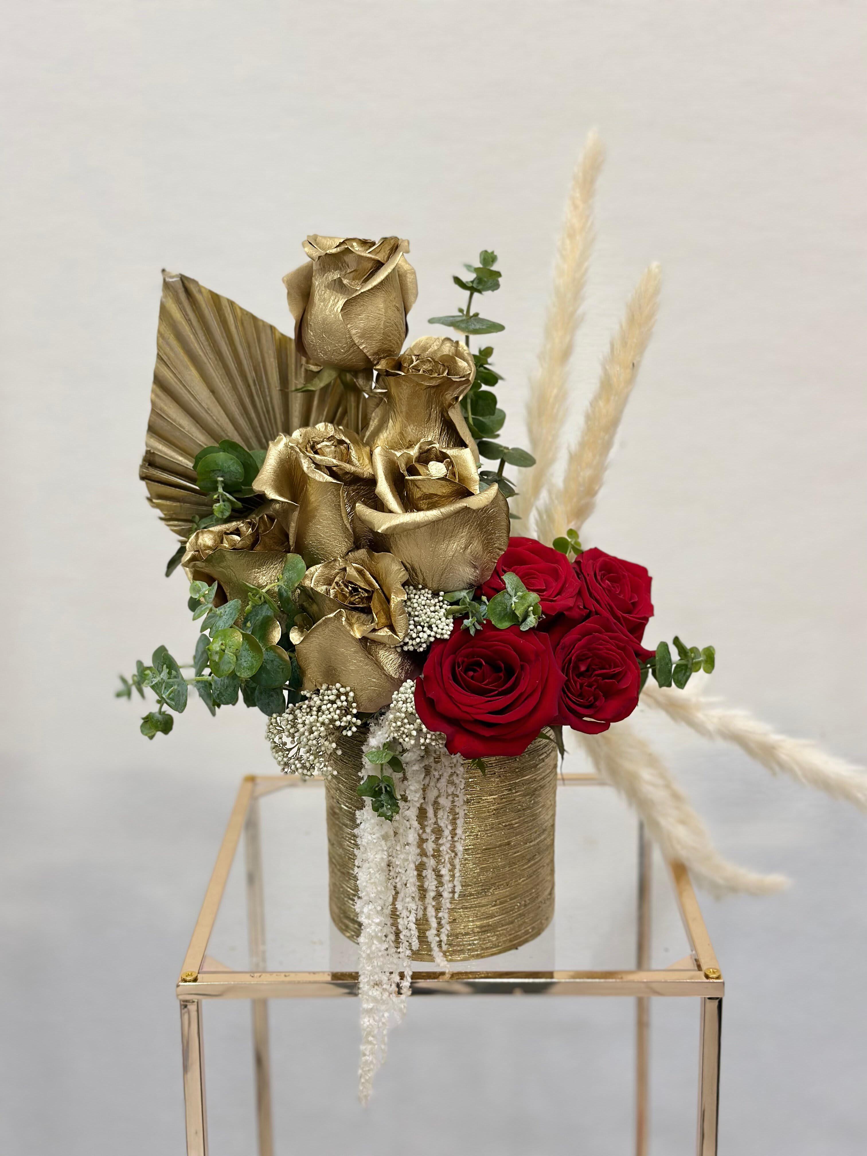 Golden Petal - Introducing a stunning arrangement that's sure to turn heads: a mix of radiant gold and fiery red roses, coming together in a harmonious display of color and elegance. Whether adorning a dinner table for a special occasion or brightening up a corner of your home, this arrangement brings a touch of warmth and sophistication to any space. 
