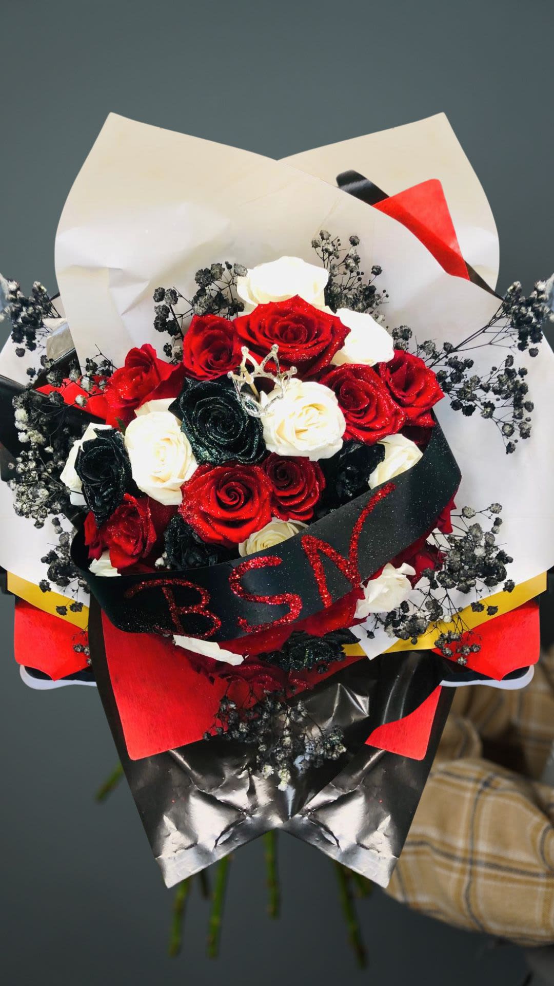 Glee & Glitter Bouquet Glee & Glitter Bouquet - 32 Stunning Roses In Red Glitter Roses, Black Glitter Roses And White Roses Designed In A Beautiful Hand-Tied Bouquet With Black Colored Babys Breath And A Crown Topper. Wrapped With Elegant Paper & Personalized Ribbon. Perfect Unique Gift For Any Occasion!