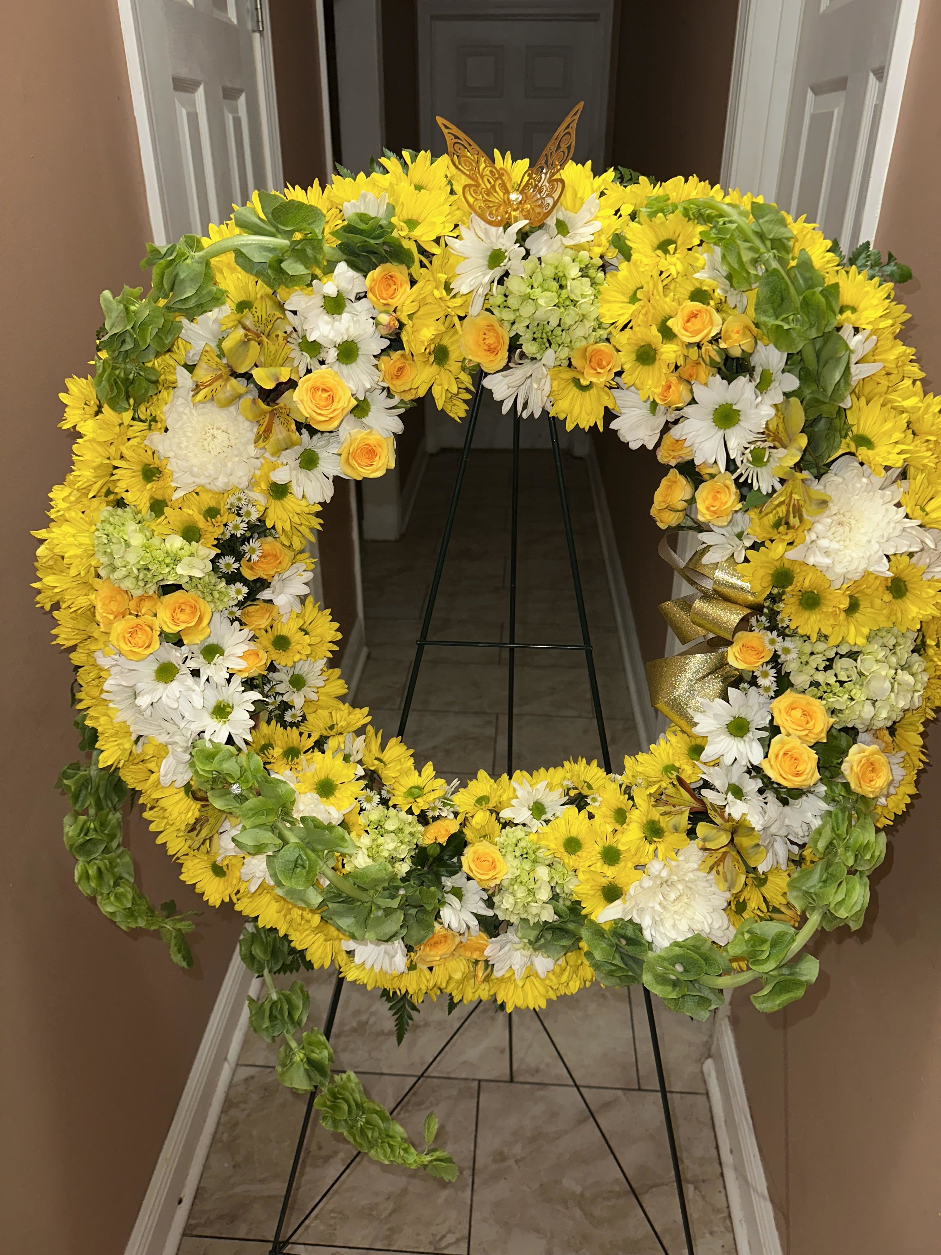 GOLDEN REMEMBRANCE WREATH - Wreath is approximately 24&quot; in diameter. Designed by florists, ready to display. Pet Safety Precautions: This bouquet or plant may include flowers and foliage that are known to be toxic to pets. To keep them safe, be sure to keep this arrangement out of your pet's reach. BLOOM DETAILS Carnation Daisy Alstroemeria/Peruvian Lily Ivy