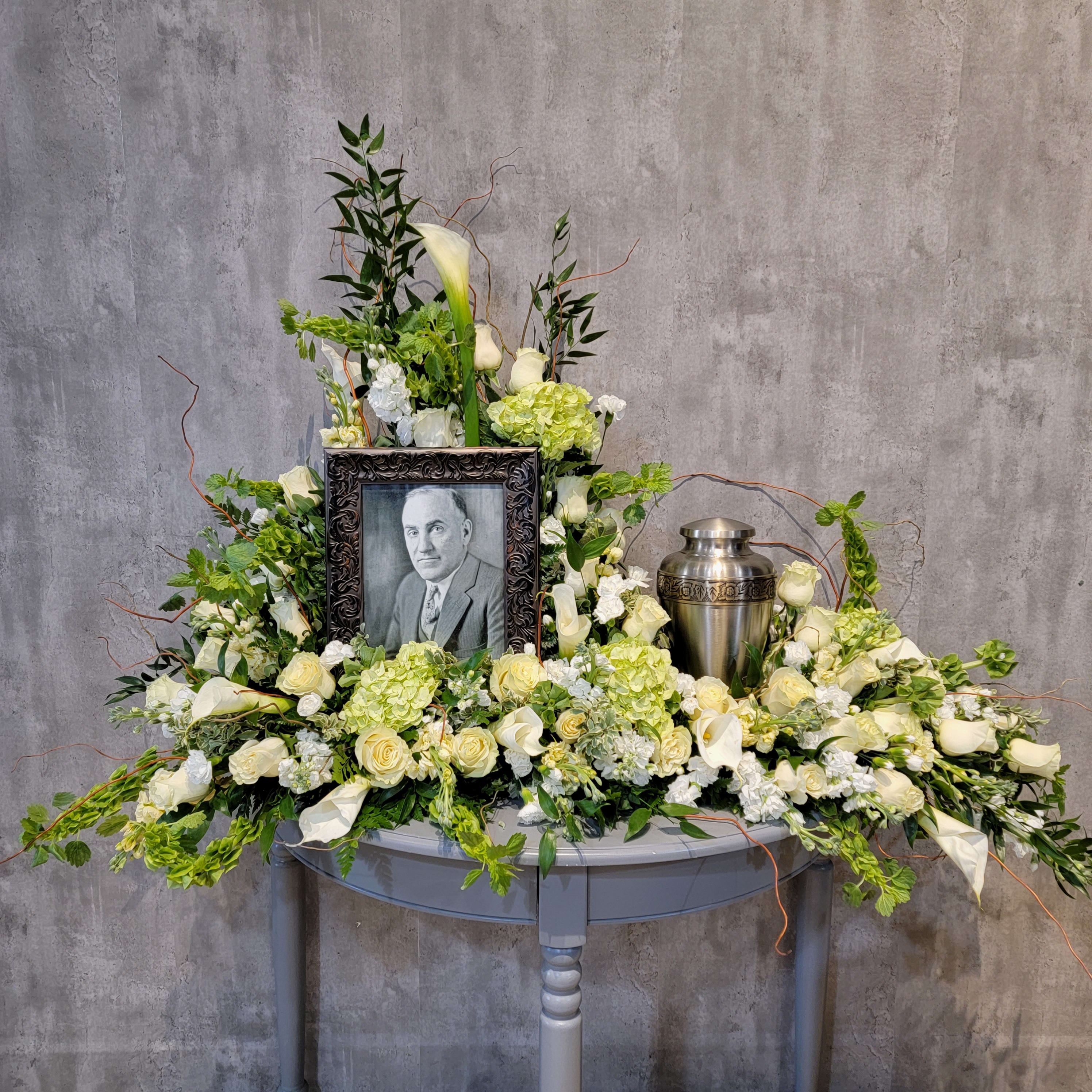 Serenity Urn Spray - Gorgeous hues of whites and greens are the perfect color combination to peacefully honor a loved one. The urn spray is designed to incorporate a photo (8x10 - 11x14) and an urn.