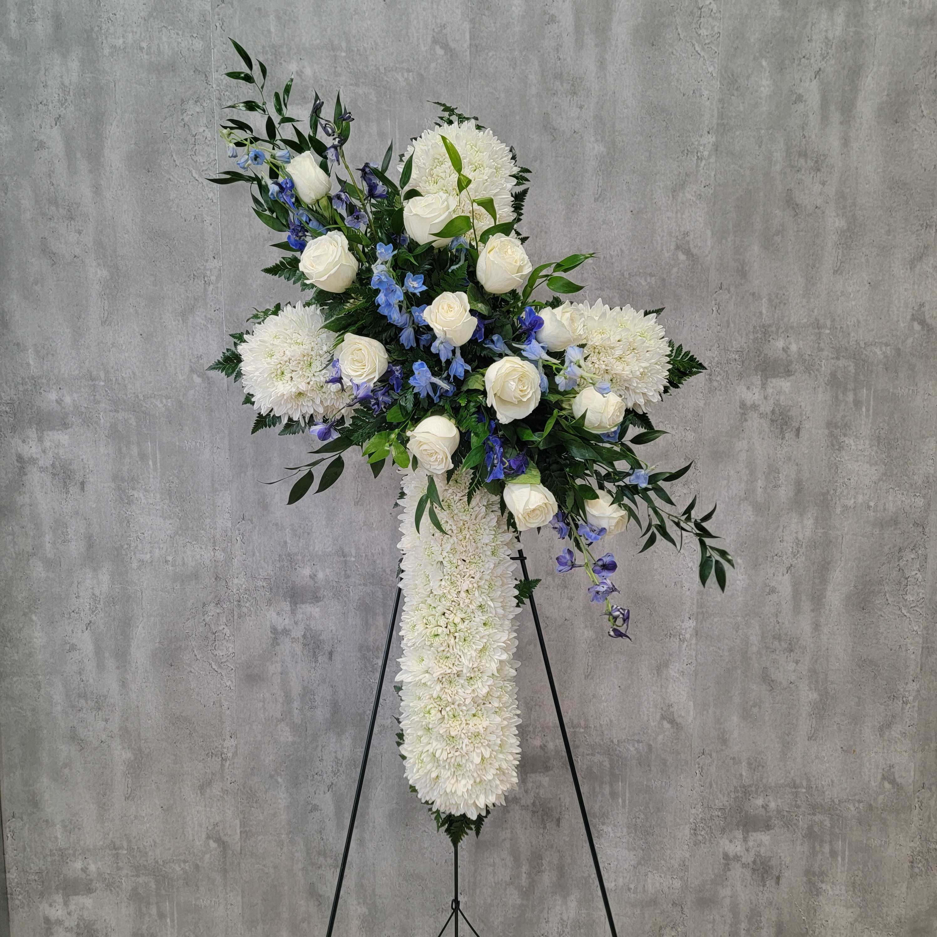 Blue Skies Cross - White cross with white roses and blue delphinium swag across. Cross is 30&quot; long.