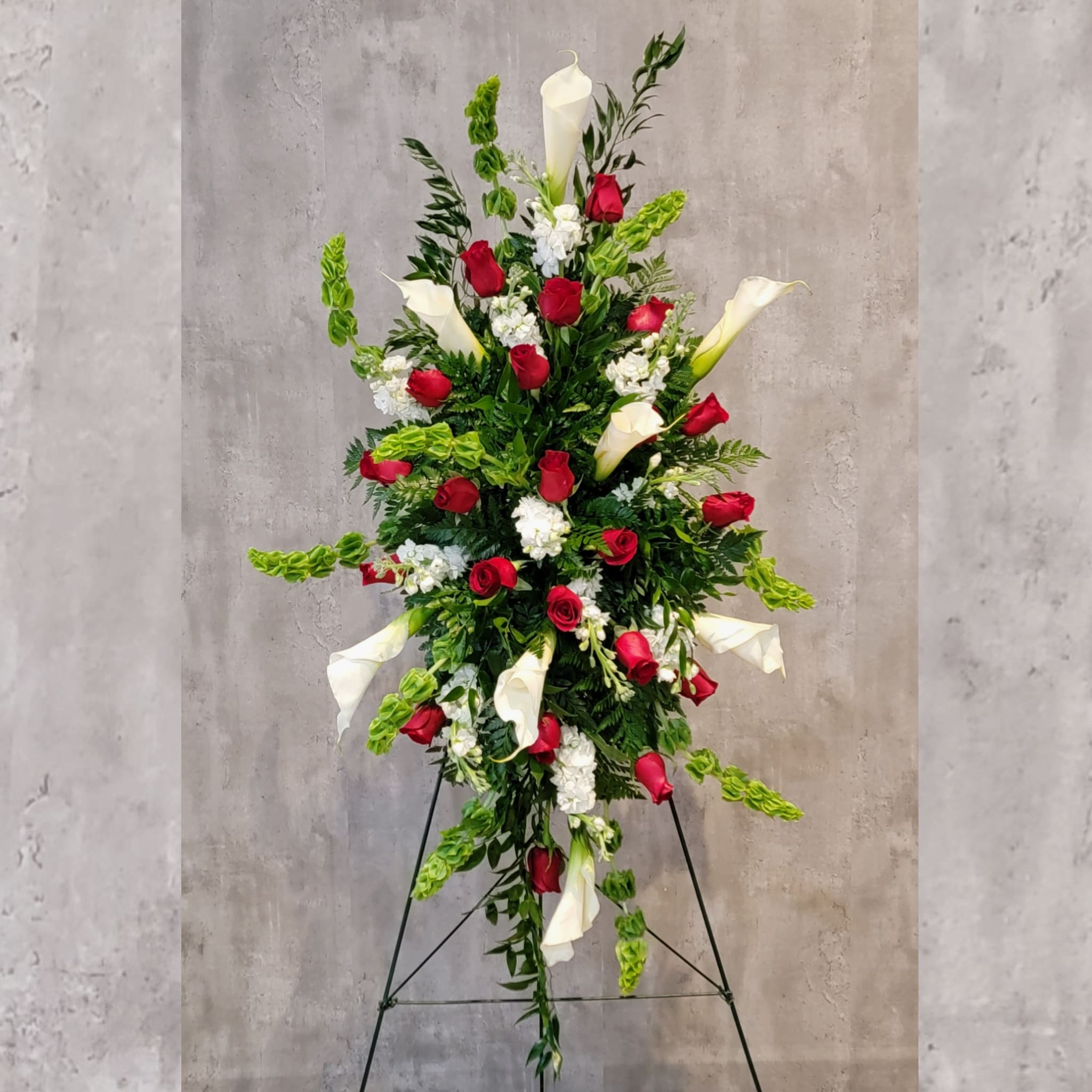 Love Easel - Gorgeous easel of red roses and white calla lilies, accented with white stock and bells of Ireland.