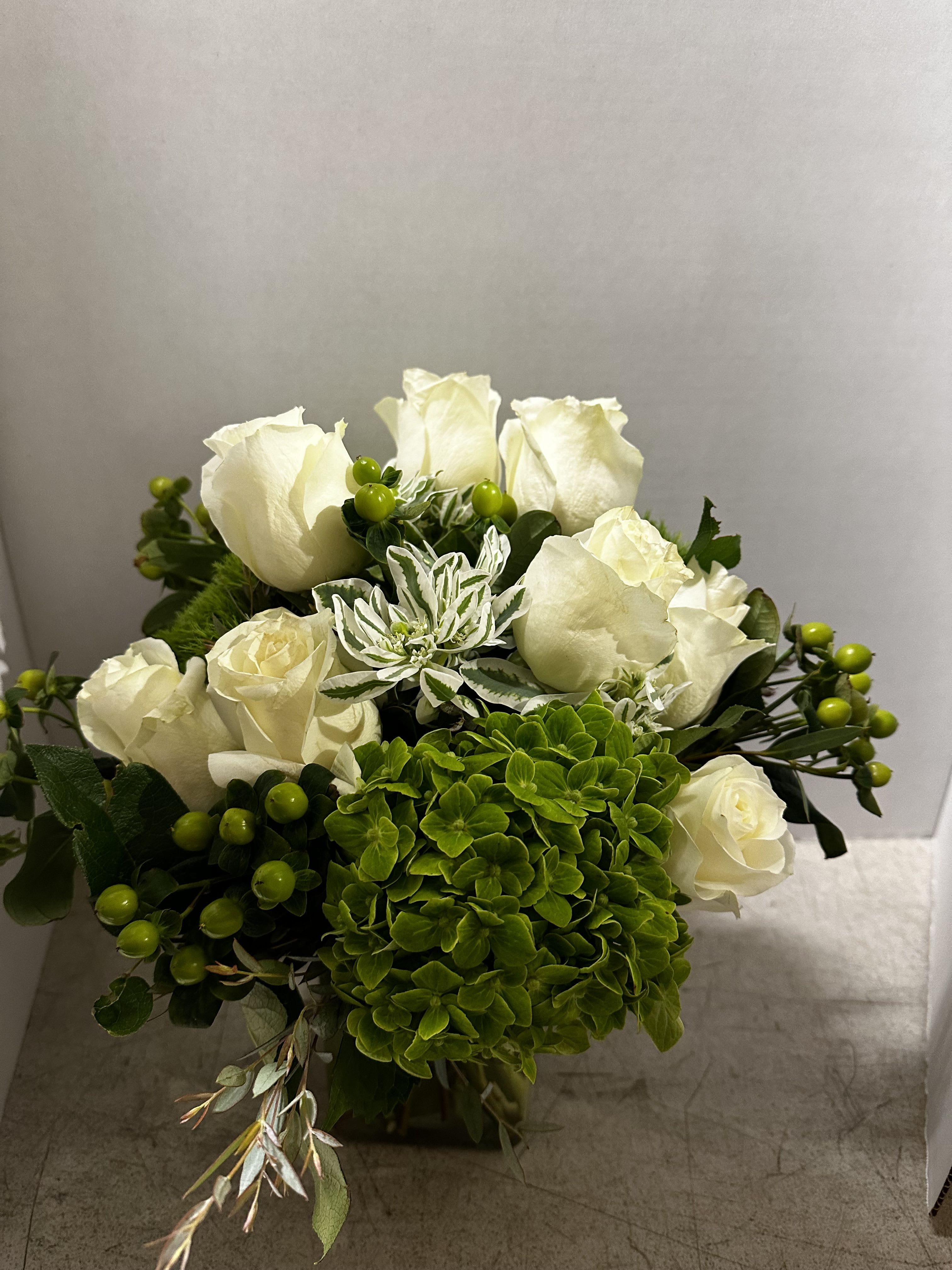 Whit and green arrangement Whit and green arrangement - White roses and green hydrangeas in a square vase
