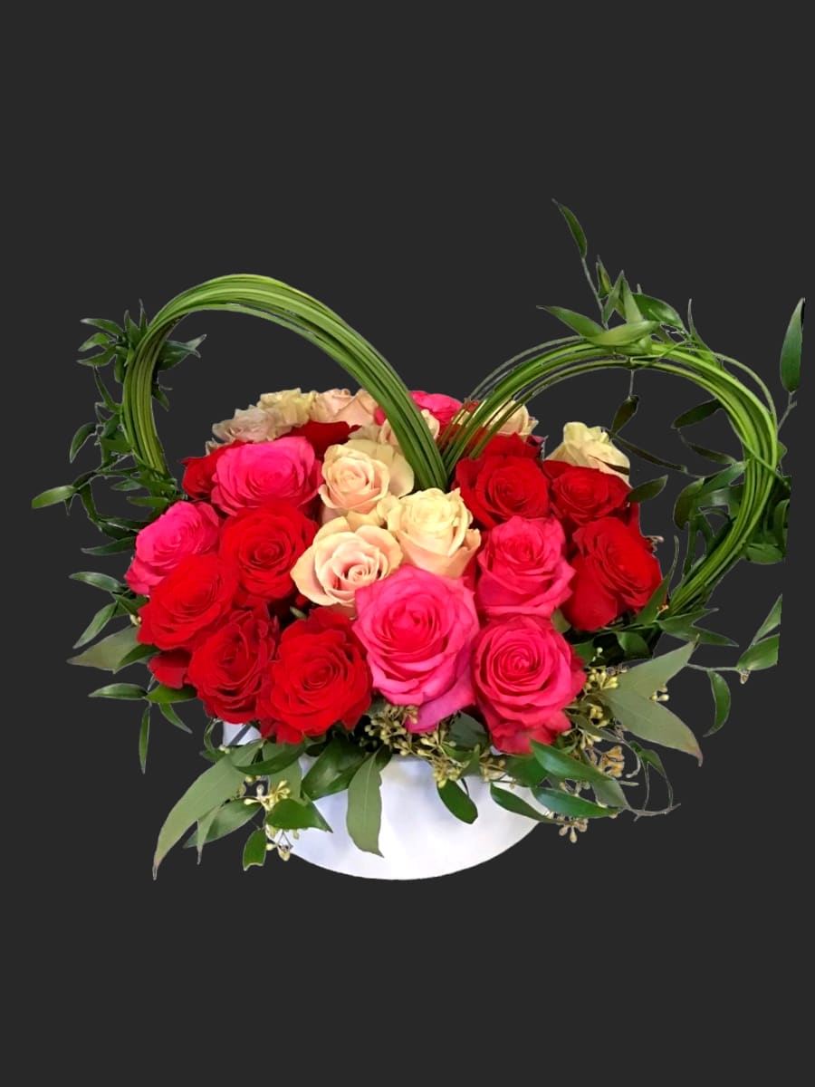36 mixed red and white roses in a low ceramic vase - simple and elegant modern design of 36 mixed roses with seeded eucalyptus greenery, bear grass and italian ruscus designed in a low ceramic vase.