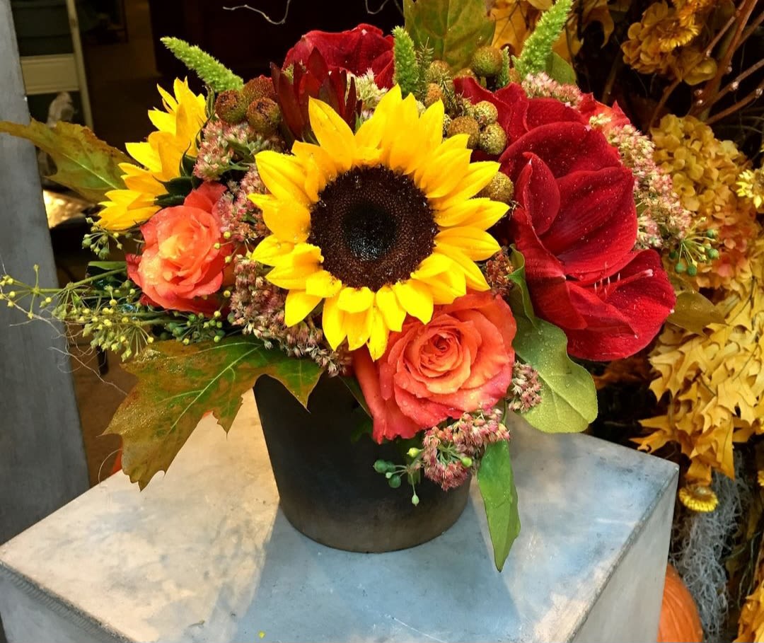 Sunbeam - The Sunbeam Bouquet is a radiant display of autumn's finest hues, designed to bring warmth and cheer to any space. Featuring vibrant sunflowers as the focal point, their golden petals shine alongside rich orange roses, symbolizing joy and passion. Accented with seasonal fall foliage in warm shades of amber, russet, and gold, this bouquet beautifully reflects the colors of a sun-drenched autumn afternoon. Perfect for brightening up your home or as a thoughtful gift, the Sunbeam Bouquet captures the essence of fall with its glowing, sun-kissed charm.
