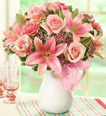 Pink Lemonade Bouquet - Product ID: 90248   EXCLUSIVE Let pink perfection permeate their day with our truly original arrangement. Designed to make any day sweeter, our florists have gathered stunning roses, lilies, carnations and waxflower in vibrant shades of pink. Hand-arranged in a reusable, food-safe ceramic pitcher and accented with pink satin ribbon, it's a gift that serves up lasting smiles. Fresh gathering of pink roses, pink lilies, pink carnations, pink waxflower and variegated pittosporum Artistically hand-designed by our select florists in a lovely white handled ceramic pitcher, accented with pink satin ribbon; pitcher measures 7.75&quot;H The food-safe pitcher can be reused to serve refreshing beverages, to hold kitchen utensils or display more fresh bouquets (see above images for examples of after use) Large arrangement measures approximately 18&quot;H x 16&quot;L Medium arrangement measures approximately 17&quot;H x 14&quot;L Small arrangement measures approximately 16&quot;H x 12&quot;L Our florists select the freshest flowers available so colors and varieties may vary Lilies may arrive in bud form and will open to full beauty over the next 2-3 days