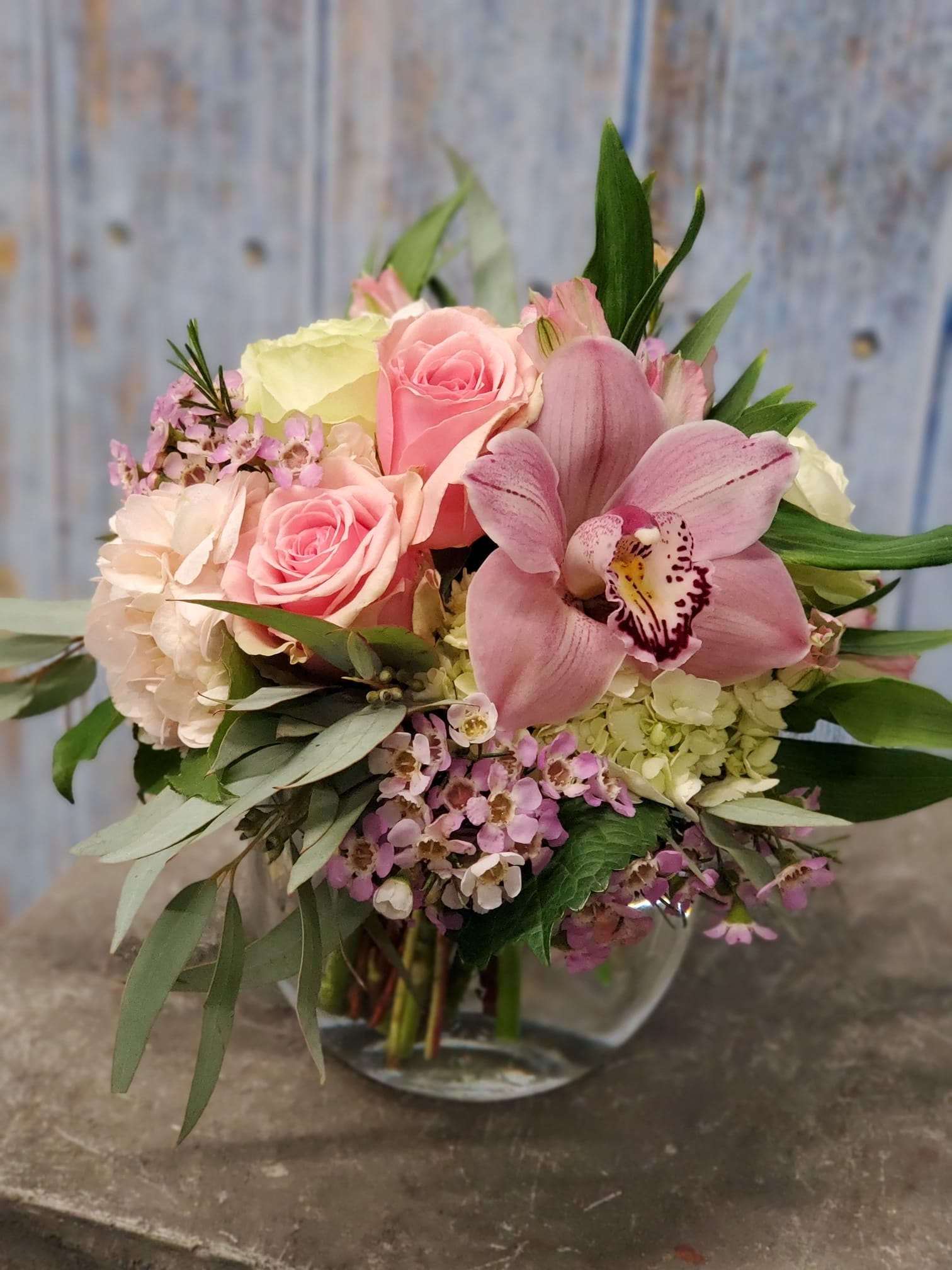 The Best Thing - Fit for a special day or any day, send &quot;The Best Thing&quot; to someone who has it all. An elegant and fresh combination of hydrangea, roses, seasonal accents, topped with a stately cymbidium orchid hand designed in a glass vessel. 