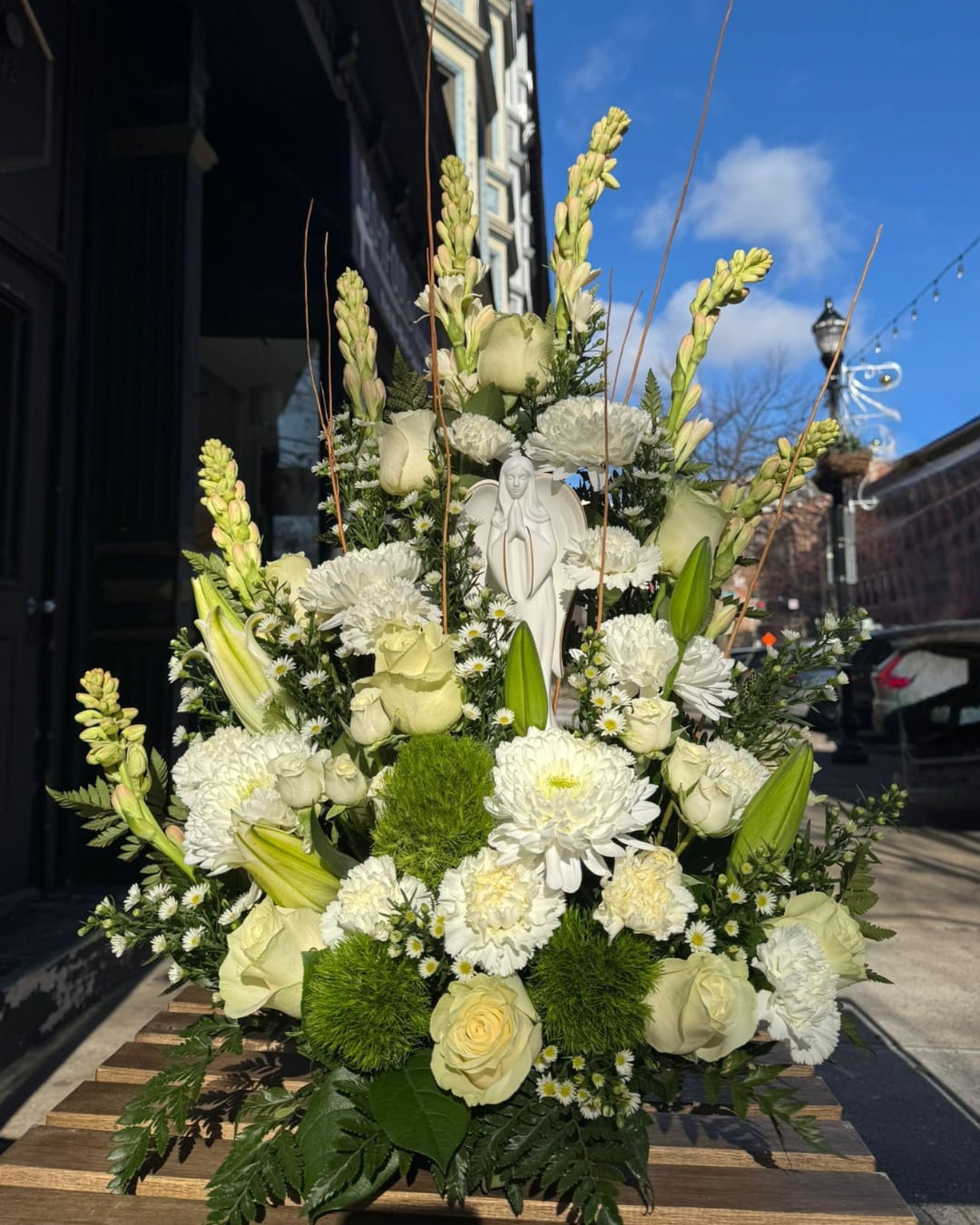 Mi Angelito. Mi Angelito. - Mi Angelito. It is a tribute to the beauty of simplicity and purity. This design, inspired by innocence and peace, includes lilies, roses and delicate seasonal flowers.