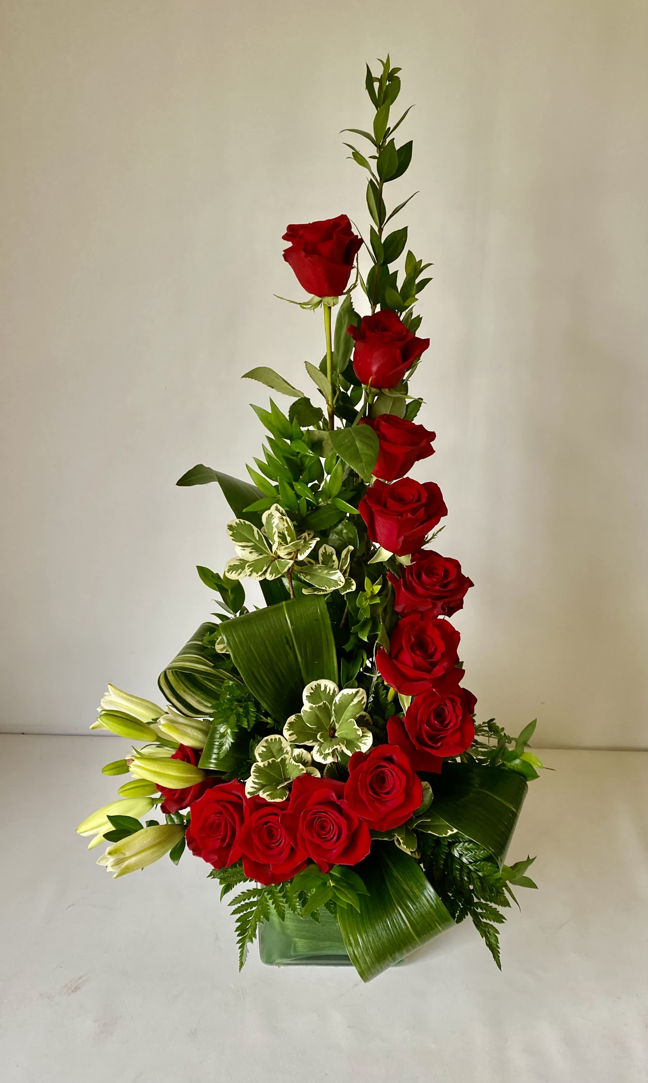 Stairway To Heaven - A dozen beautiful red roses with white accent flowers beautifully arranged in a glass cube. This arrangement is suitable for a variety of occasions. White flower varieties may vary due to availability. 
