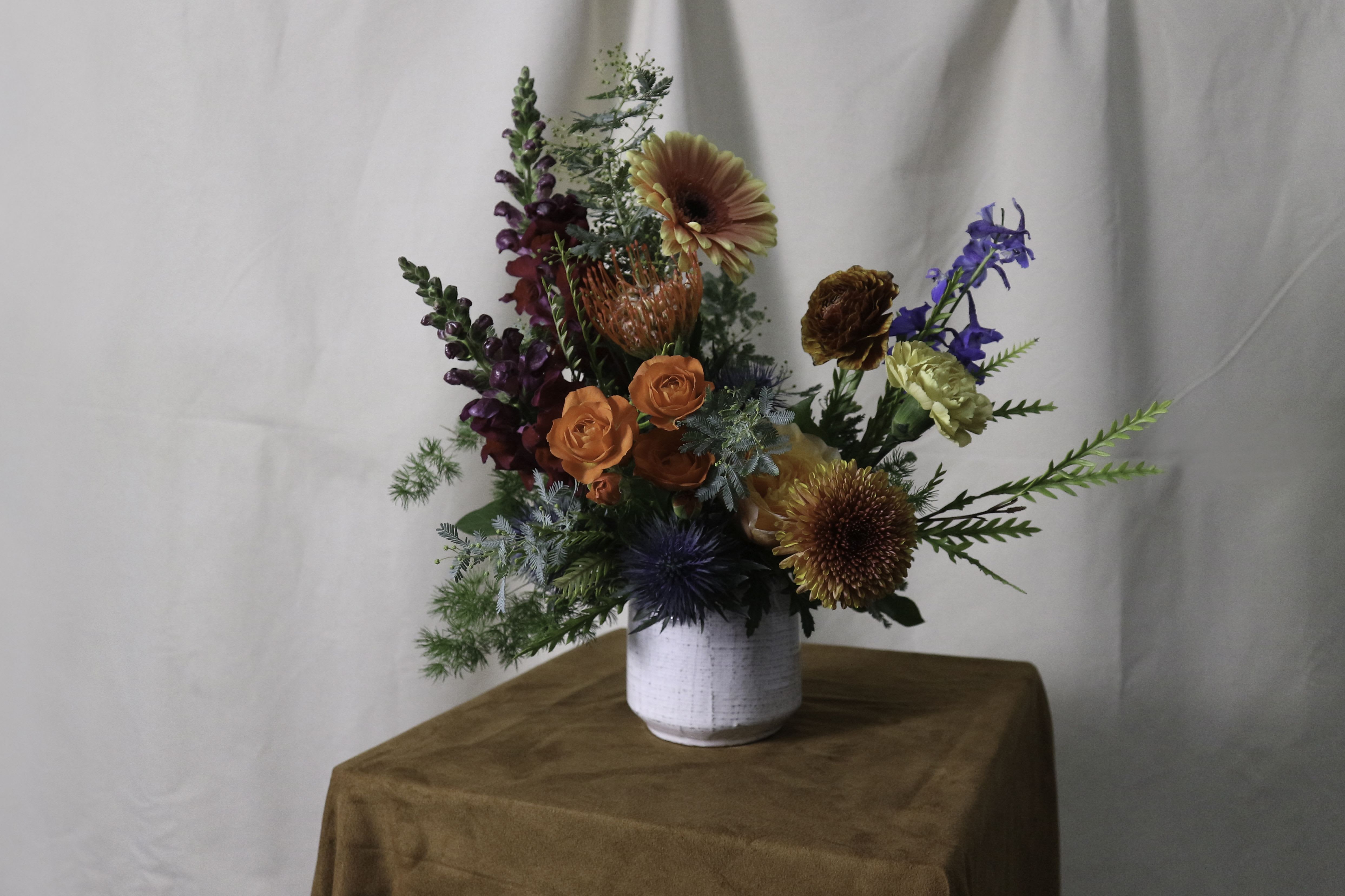 Designer's Choice : Vase Arrangement - Leave it to us to create something stunning! Our Designer’s Choice vase arrangement features the freshest seasonal flowers, thoughtfully styled in a beautiful vase. Whether it’s bold and vibrant or soft and elegant, this one-of-a-kind design is made to impress and perfectly suit the moment.  ---------------------- At The Burmese Cat Floral Studio, we celebrate the uniqueness of every flower and vase. While the photo captures the spirit of your arrangement, some elements—like one-of-a-kind vessels or seasonal stems—might not always be exactly the same. However, each arrangement will embody the same charm, elegance, and artistic flair.  If substitutions are needed due to weather, seasonal shifts, or market availability, we’ll stay true to the mood, colors, and style you’ve chosen. Rest assured, any replacements will match or exceed the value of the original design.  If there’s something specific that’s a must-have for your arrangement, just let us know in the notes at checkout or reach out directly—we’ll do our best to make it happen! ----------------------
