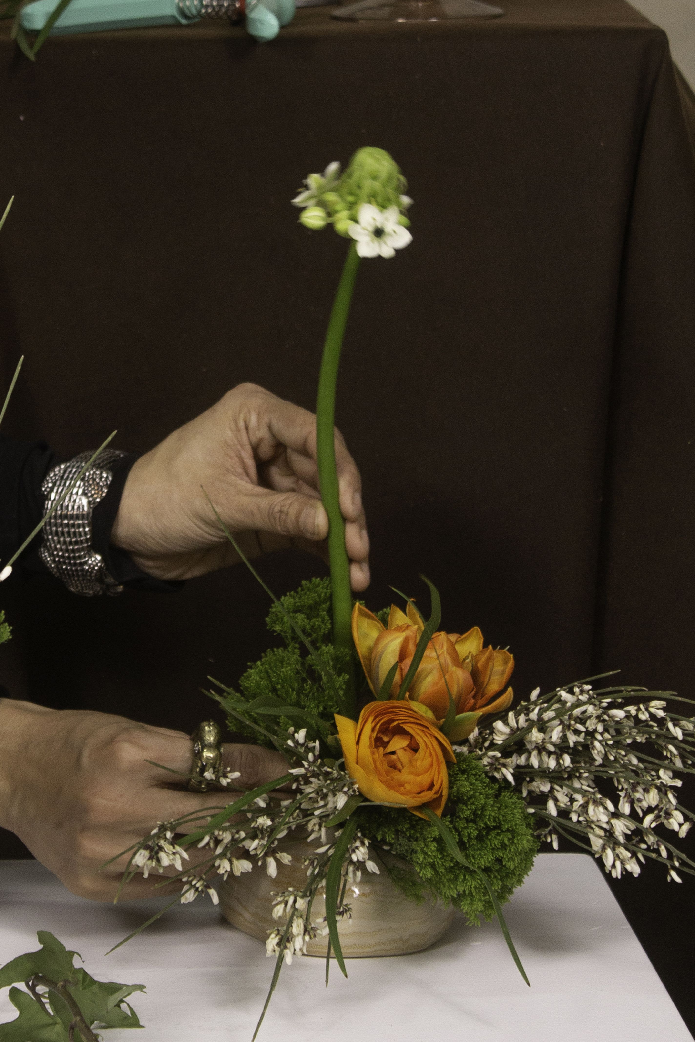Nawaday - Featuring vibrant orange ranunculus paired with delicate white star-shaped flowers and soft green moss, Nawaday is a mix of a stunning contrast of bold and subtle textures. Accented with fine sprigs of white heather, the design is both dynamic and elegant, capturing a sense of movement and organic beauty. Perfectly sized for intimate spaces, this bud vase evokes a feeling of contemporary charm and timeless grace.  *Please note that this listing is for the bud vase arrangement only. Any additional items or props visible in the photos, such as decorative objects or background elements, are included for aesthetic presentation and size comparison purposes and are not part of the sale.*  ---------------------------------------------------  At The Burmese Cat Floral Studio, we celebrate the uniqueness of every flower and vase. While the photo captures the spirit of your arrangement, some elements—like one-of-a-kind vessels or seasonal stems—might not always be exactly the same. However, each arrangement will embody the same charm, elegance, and artistic flair.  If substitutions are needed due to weather, seasonal shifts, or market availability, we’ll stay true to the mood, colors, and style you’ve chosen. Rest assured, any replacements will match or exceed the value of the original design.  If there’s something specific that’s a must-have for your arrangement, just let us know in the notes at checkout or reach out directly—we’ll do our best to make it happen!