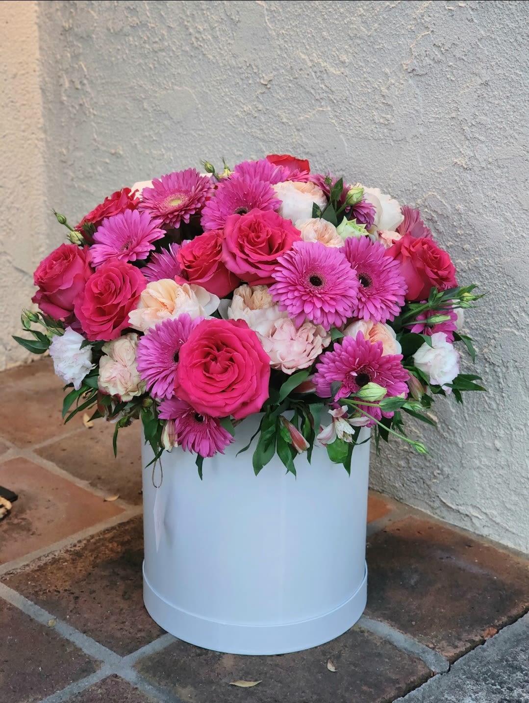 Miss Pink Bouquet  - Vibrant floral arrangement, beautifully displayed in a white hatbox. This stunning mix of flowers in captivating shades of pink, peach roses. Eye-catching bouquet that exudes elegance and joy. Perfect for adding a splash of color to any occasions 
