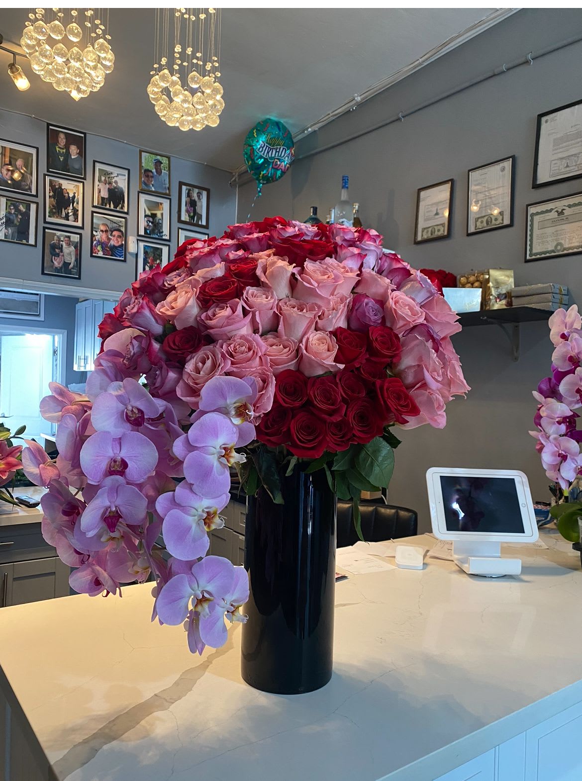 Your Majesty - A gorgeous black Cylinder vase with a really good selection of pink, hot pink, blush and red roses with orchids 