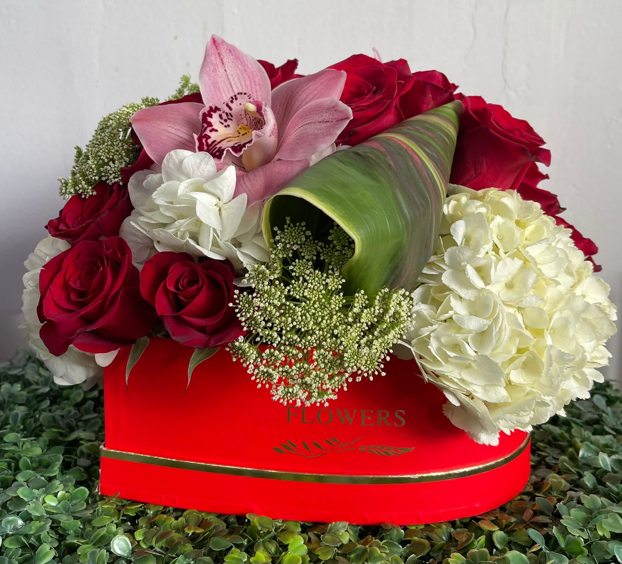RED PASSION RED PASSION - HEART SHAPE BOX WITH ROSES, HYDRANGEA AND A TOUCH OF AN ORCHILD.