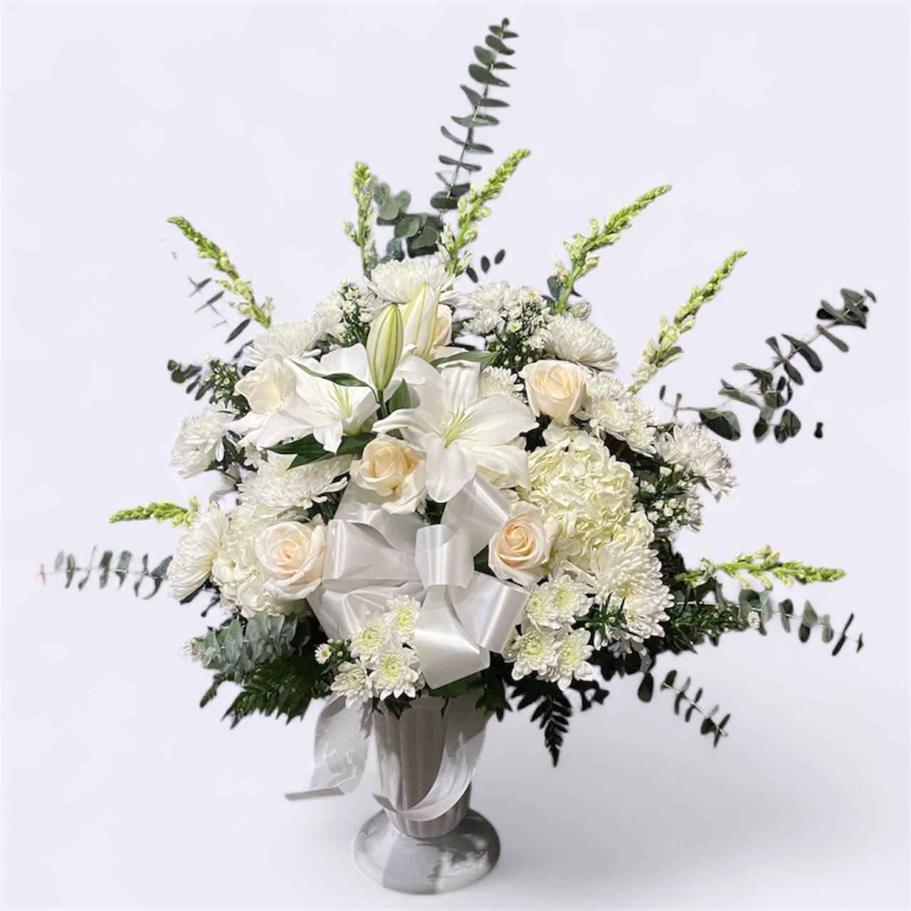 Peace Peace - This piece has all white mixed flowers, lilies, roses, mums, hydrangeas, monte casino, and snapdragons.
