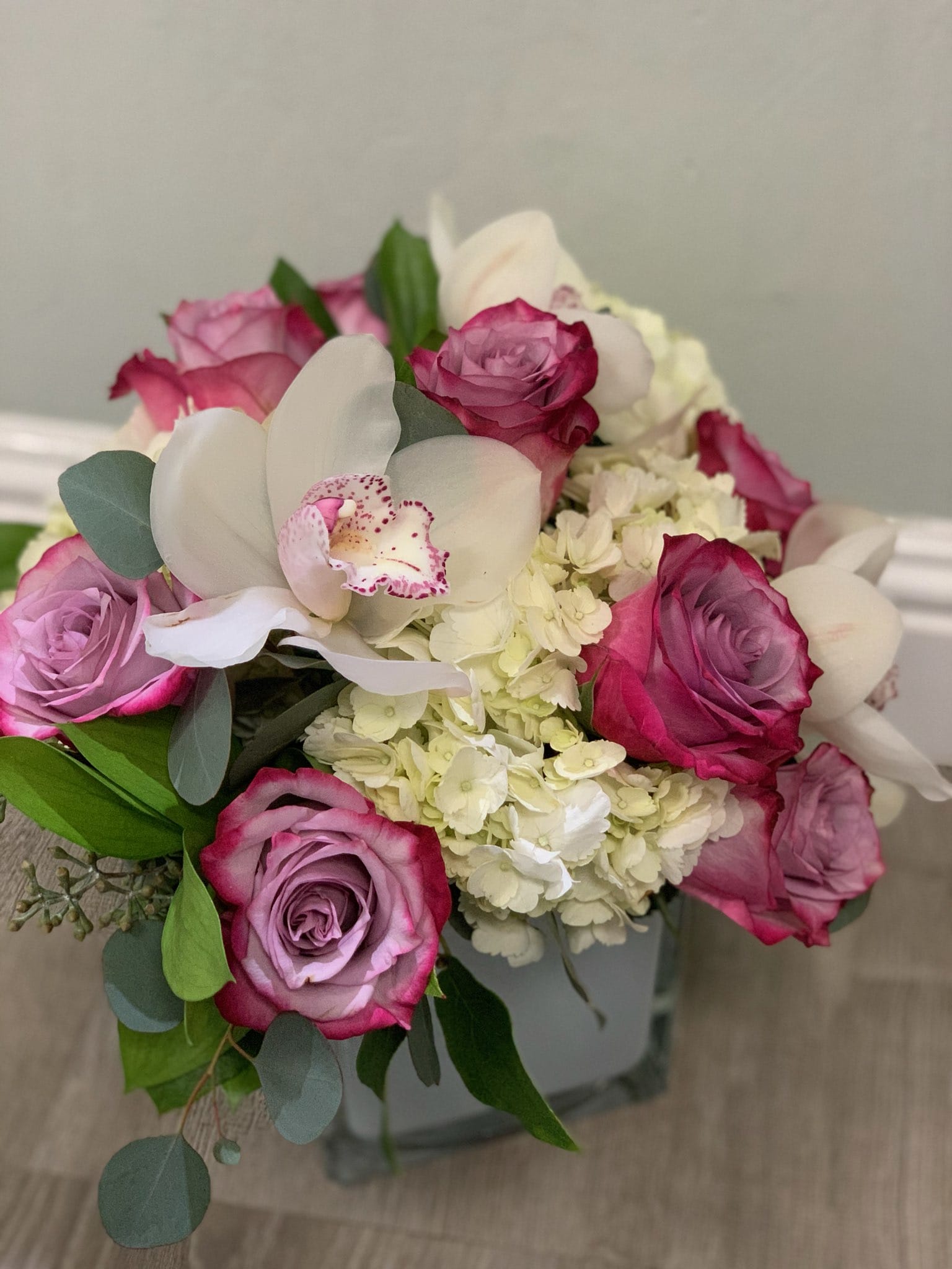 Pop of Lavender by BloomNation™ - Our most popular arrangement! Pop of Lavender by BloomNation™ is the perfect gift to wish someone a happy birthday or to say thank you or thinking of you or I love you. Includes white cymbidium orchids, lavender roses, and white hydrangea.  