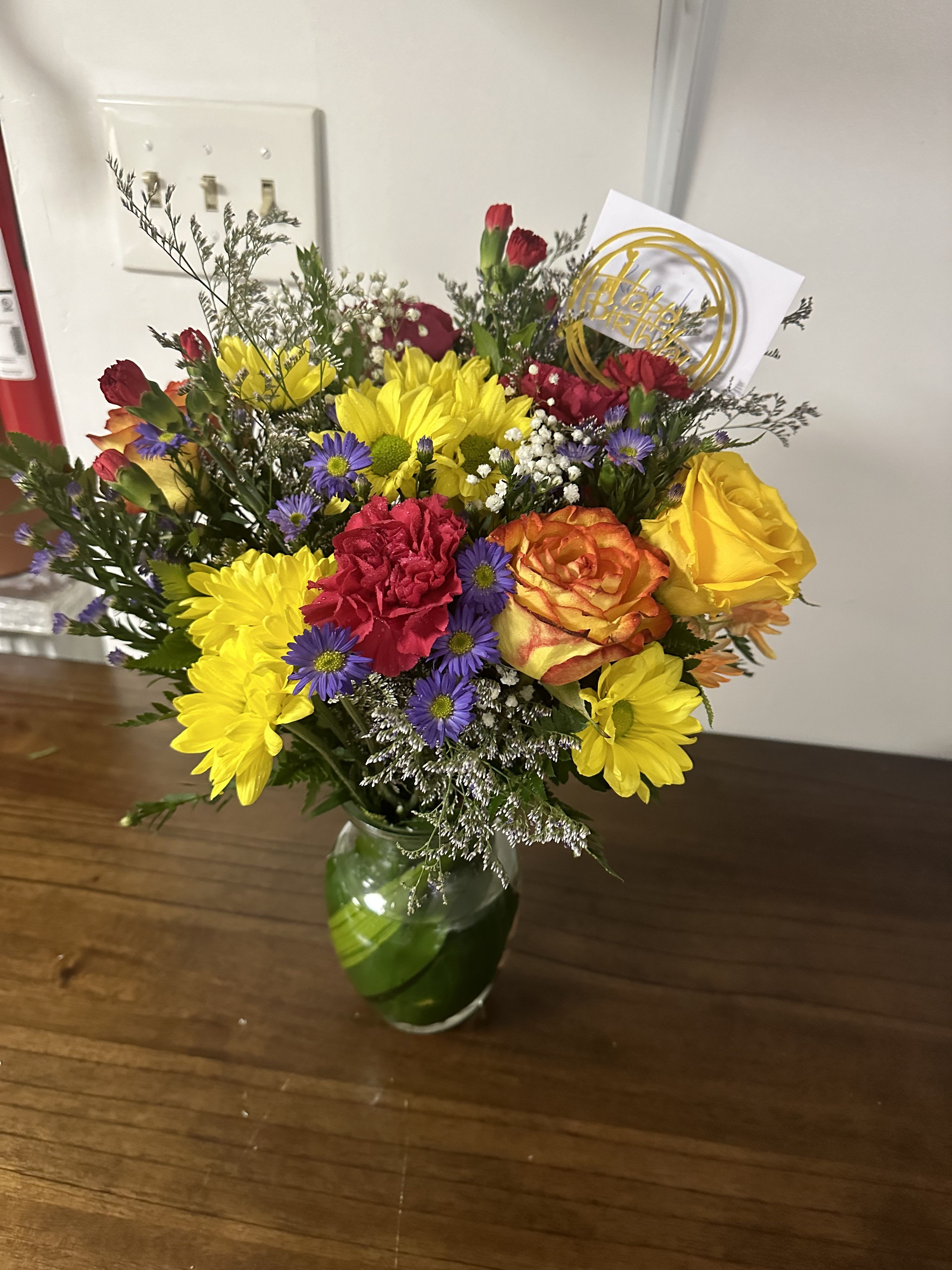 Happy Birthday 2 You - Arrangement in a clear vase. Contains assortment of flowers such as roses and carnations.