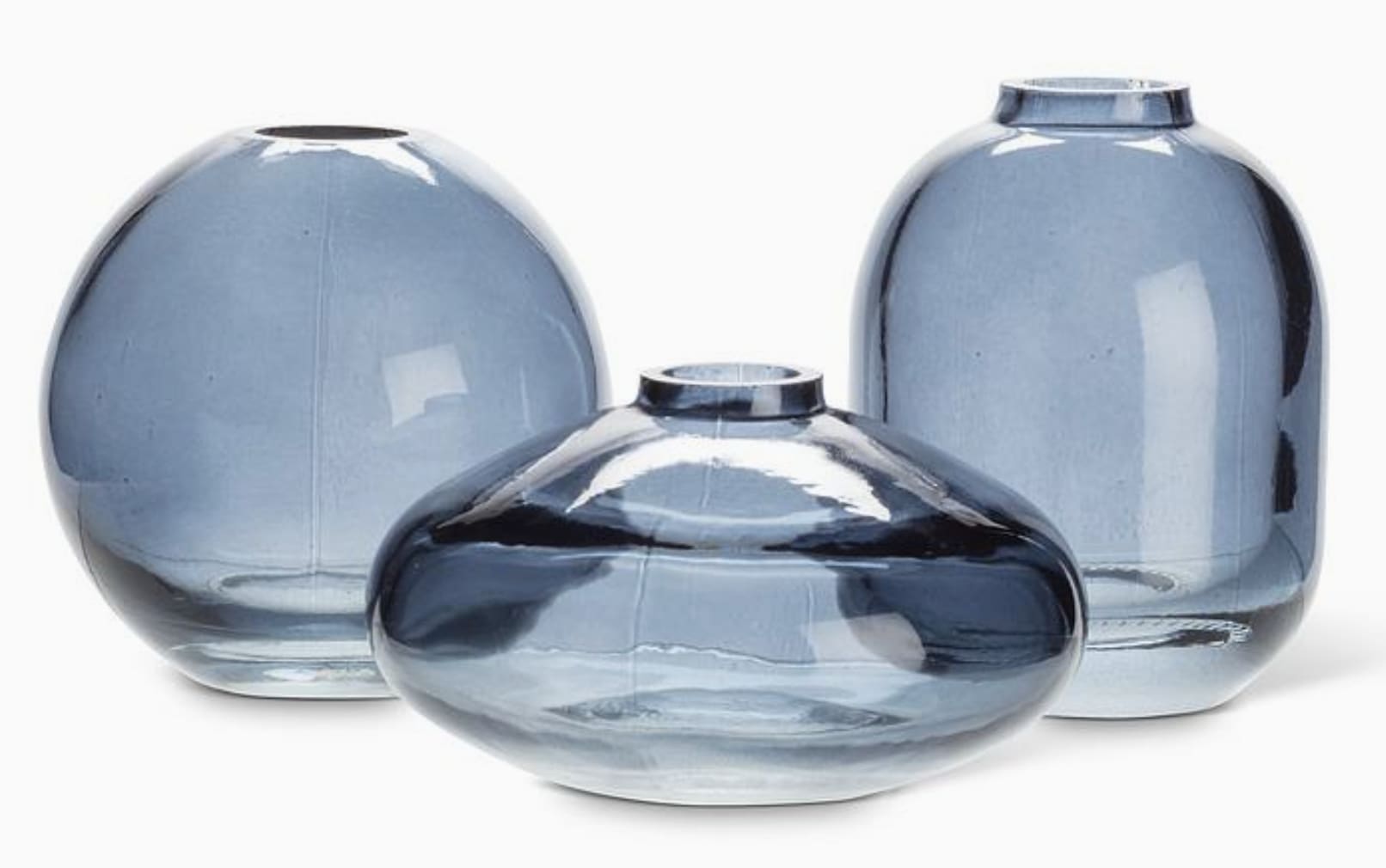 Small Bud Vase - Blue - Our Small Bud Vases in dark navy add a pop of personality and style to your home decor. Crafted from high-quality glass and available in three distinct shapes, these vases beautifully showcase single blooms or small arrangements. Whether displayed individually or grouped together, these artfully crafted colored glass bud vases bring beauty and sophistication to any space. Additional shapes and colors are available.  Dimensions: 3 x 3 x 3 in  Please note: Vases are sold individually - not sold as a set. Leave a note with your order with your preferred shape.