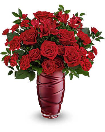 Love Blossoms Bouquet - Express your feelings boldly with this striking Valentine's Day bouquet of stunning red roses, elegantly arranged in a pearlescent glass vase featuring a captivating swirling design. This Valentine's Day arrangement features vibrant red roses, red spray roses, and rich red alstroemeria, along with charming red carnations. Accented with lemon leaf and huckleberry, Teleflora's Love Blossoms Bouquet is beautifully presented in Teleflora's Loving Swirls Vase. Orientation: All-Around  SUBSTITUTION POLICY – Always deliver the freshest flowers! Please note the bouquet pictured reflects our original design.  If the exact flowers or container in this arrangement are not available, our local florists will create a beautiful bouquet with the freshest available flowers. 