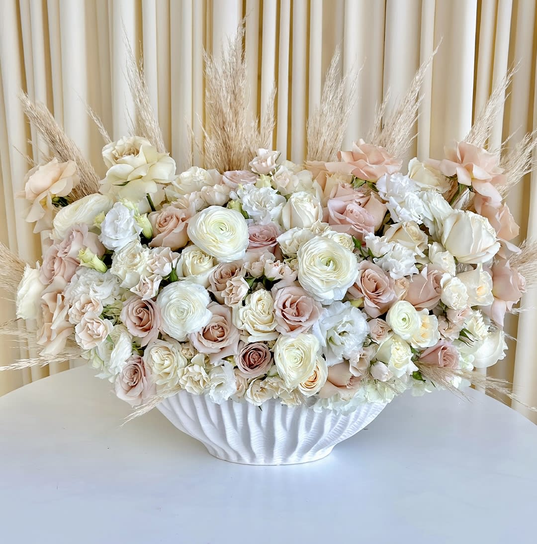Ethereal Harmony - Welcome the serene beauty of &quot;Ethereal Harmony,&quot; a captivating flower arrangement featuring a delightful blend of neutral hue flowers. Soft and elegant, this arrangement brings a sense of tranquility and balance to any space.  A carefully curated selection of flowers in muted tones, such as creamy whites, gentle blush, and earthy greens, come together to create a symphony of subtlety and grace. Each bloom chosen for its understated elegance, symbolizing purity, peace, and natural beauty.  &quot;Ethereal Harmony&quot; serves as an ideal gift for various occasions, from expressing sympathy and support to celebrating life's milestones with a touch of refined simplicity.
