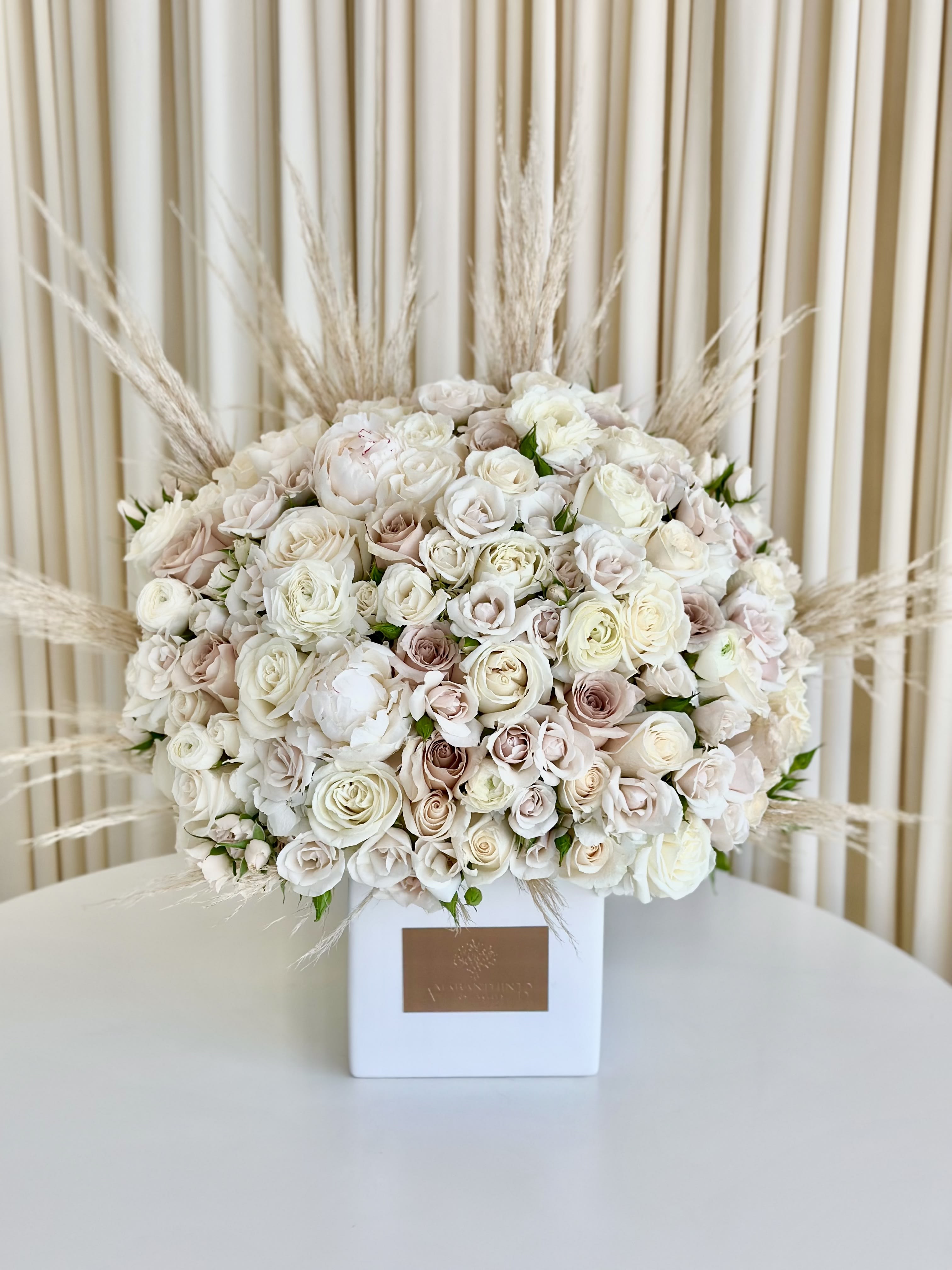 Charming Neutrals - Experience the elegance of simplicity with our &quot;Charming Neutrals&quot; flower arrangement. Delicate and enchanting, this lovely arrangement features an assortment of neutral-colored florals gracefully arranged in a cute small vase. The soft and soothing hues of these blooms complement any decor, making it a versatile and heartwarming gift for all occasions. Embrace the beauty of understated charm and bring a touch of serenity into your life or surprise someone special with this captivating arrangement.
