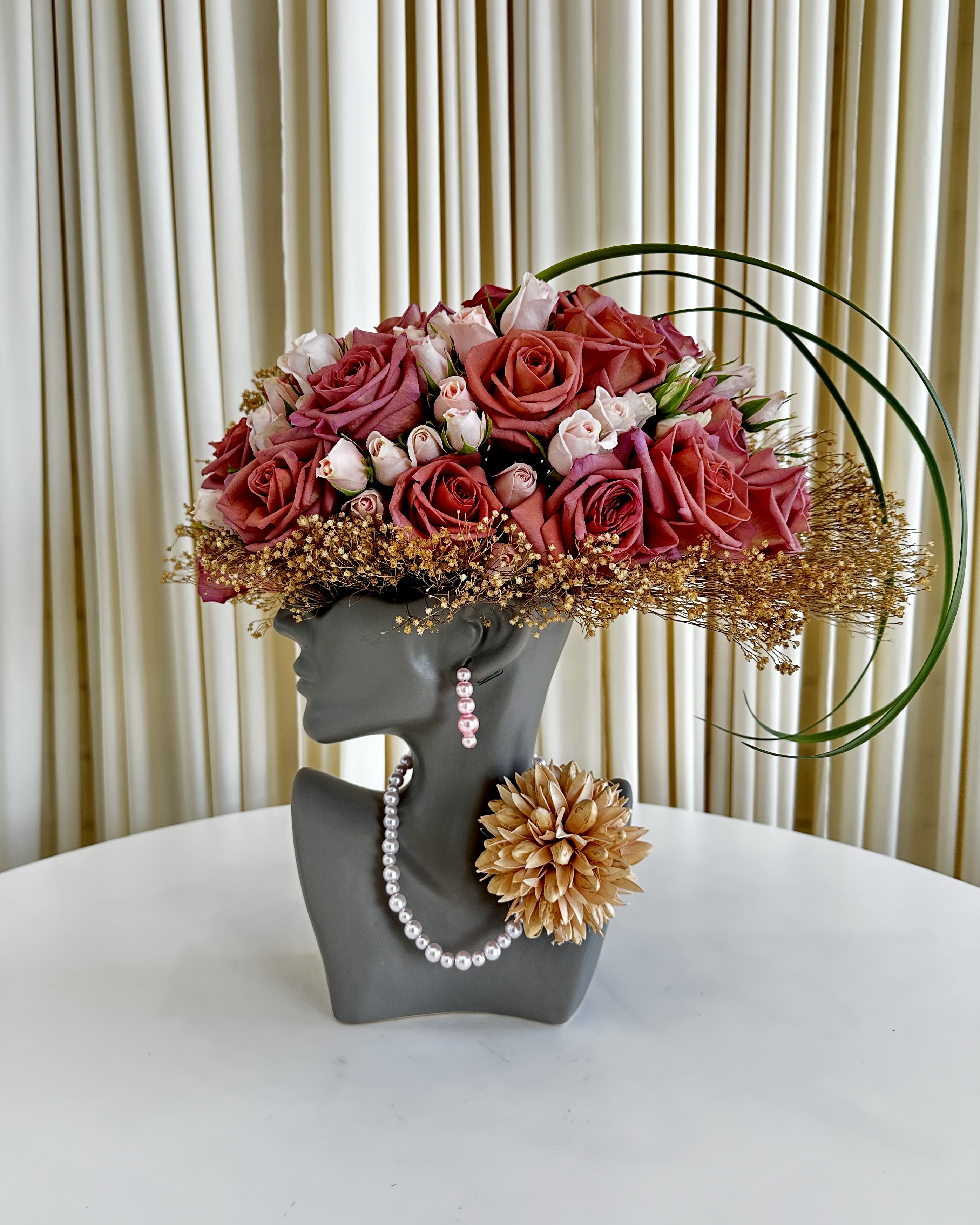 Eternal Floral Sculpture - Unveil the epitome of artistic elegance with our &quot;Eternal Floral Sculpture&quot; – a breathtaking flower arrangement thoughtfully displayed atop a head sculpture vase. Bursting with brilliantly bright colored florals, this masterpiece captures the essence of timeless beauty and creative expression. Let this exquisite floral sculpture elevate your space, making a striking statement that will leave a lasting impression. Discover the perfect blend of art and nature in one captivating creation. 