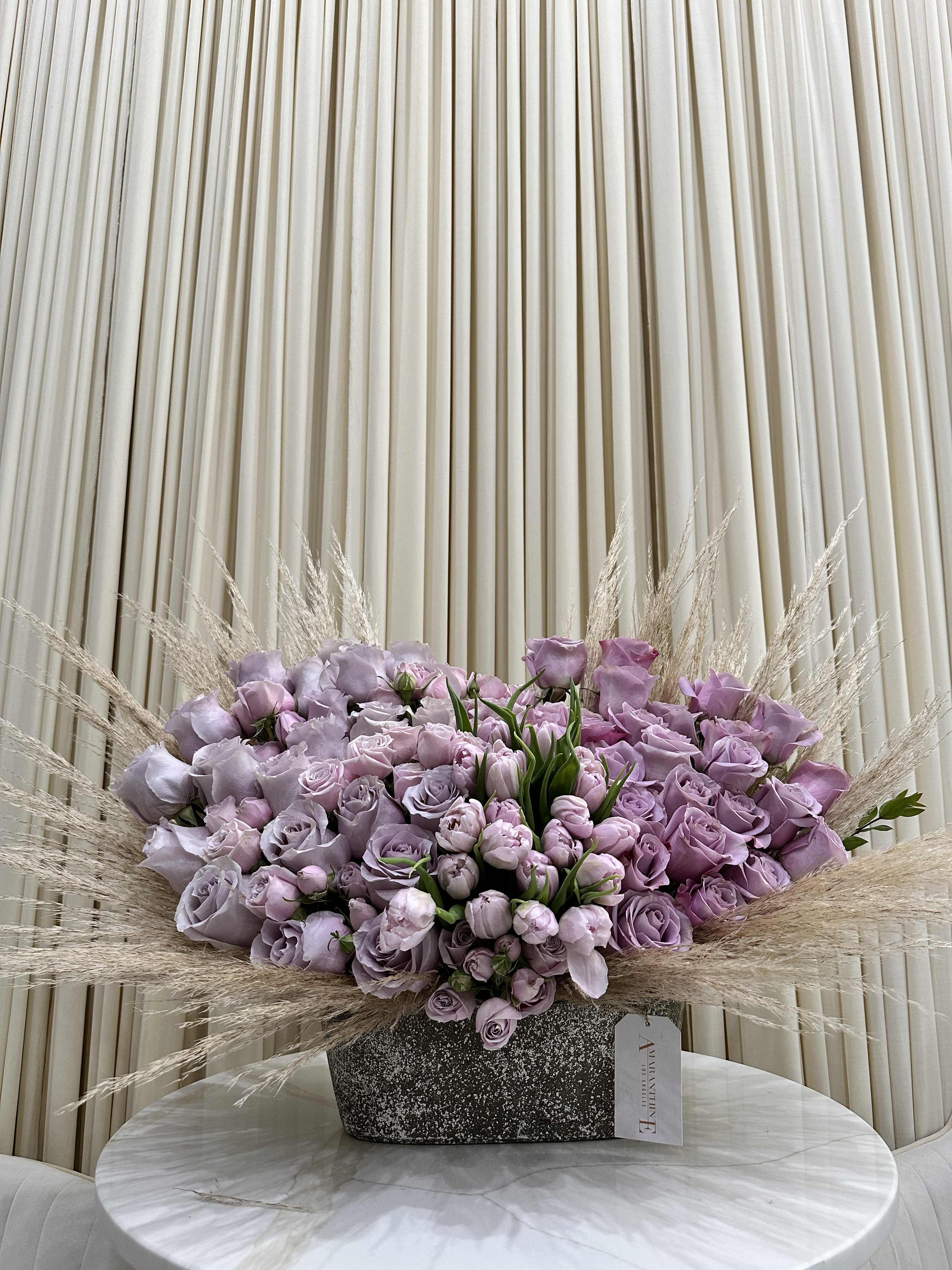 Twilight Tapestry - his mesmerizing bouquet features a beautiful ombre blend of purple roses and tulips, reminiscent of a breathtaking twilight sky.  Arranged with pops of greenery, this enchanting bouquet is sure to take anyone's breath away.