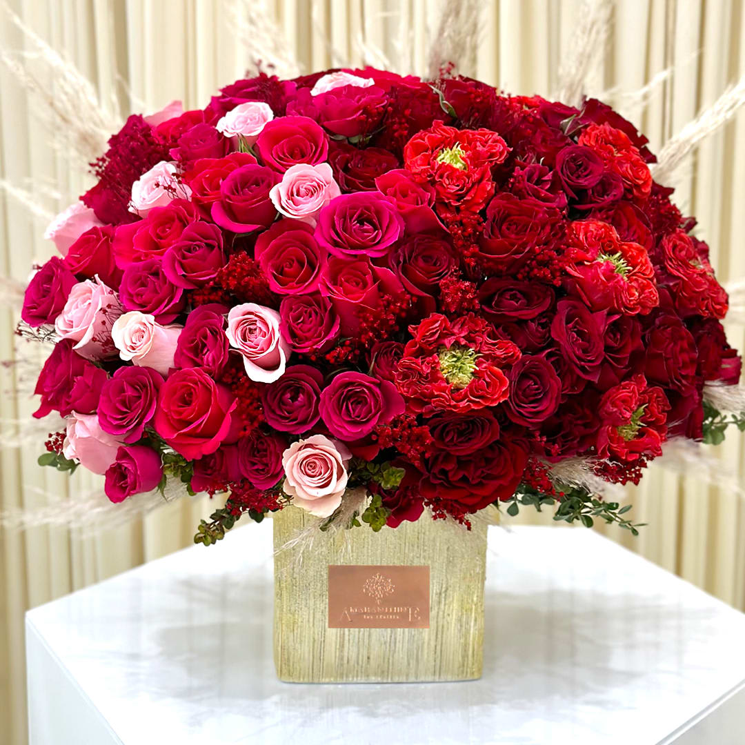 Harmony in Gold Harmony in Gold - Embrace the perfect fusion of romance and vibrancy with our "Harmony in Gold" flower arrangement. This stunning arrangement features a captivating contrast of bright pink flowers gracefully mingling with vibrant red florals, all beautifully presented in an elegant gold vase. A harmonious blend of colors that symbolize love, passion, and joy, making it an ideal centerpiece for celebrations or a heartfelt gift to express your deepest emotions. Illuminate any space with this exquisite floral masterpiece, handcrafted to bring joy and delight to your special moments.