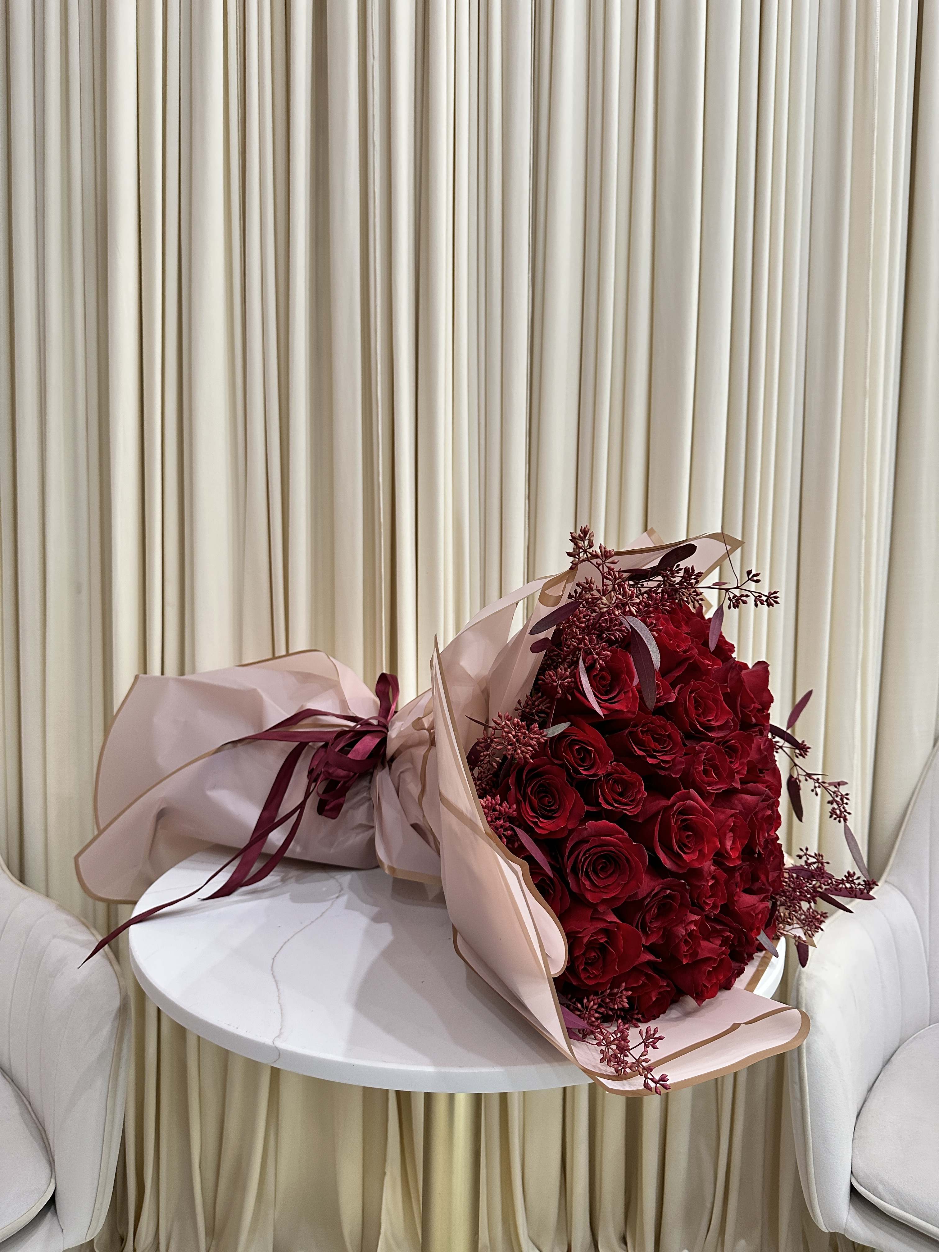 Love Story Bouquet -  This stunning bouquet is sure to take her breath away. It features 25 vibrant red roses, each one perfectly bloomed and bursting with color. The roses are professionally arranged, creating a luxurious and unforgettable gift.