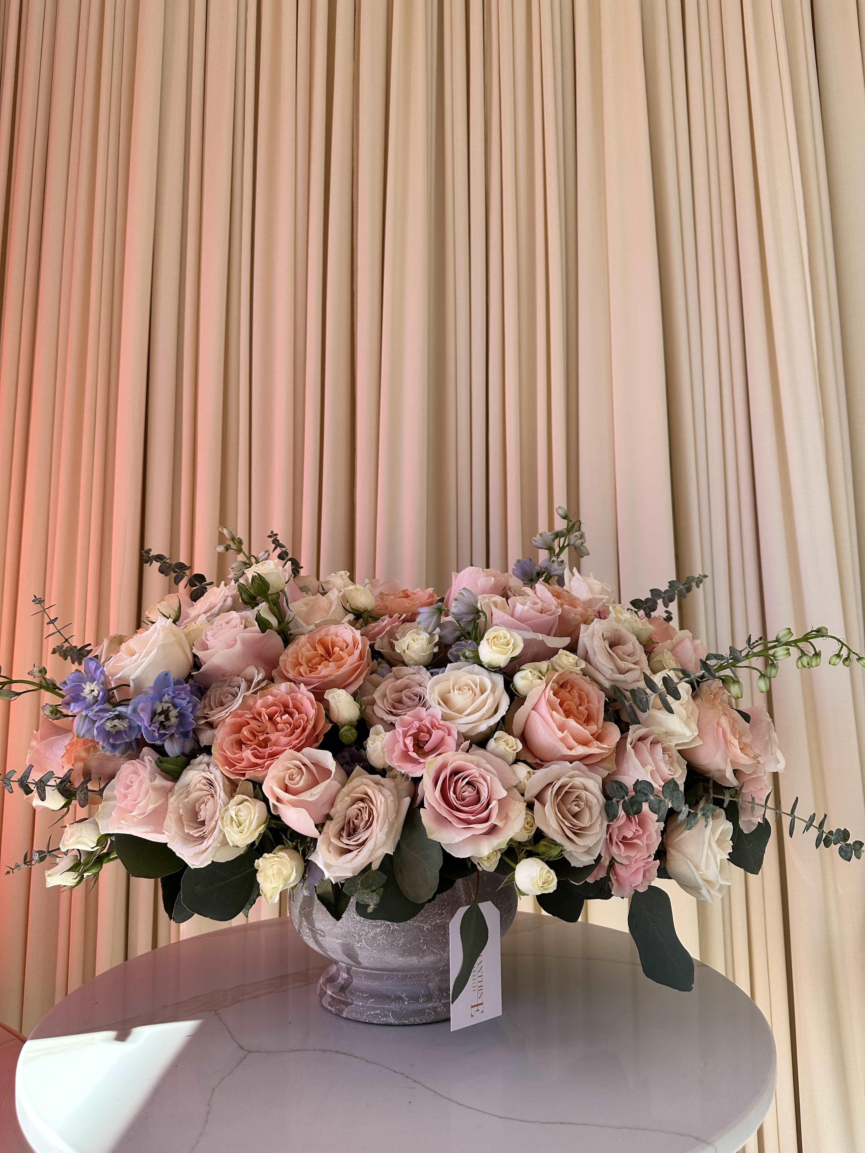 Sunlit Fields - Capture the joy of a summer day with this vibrant bouquet featuring roses, baby roses, and delphinium.   