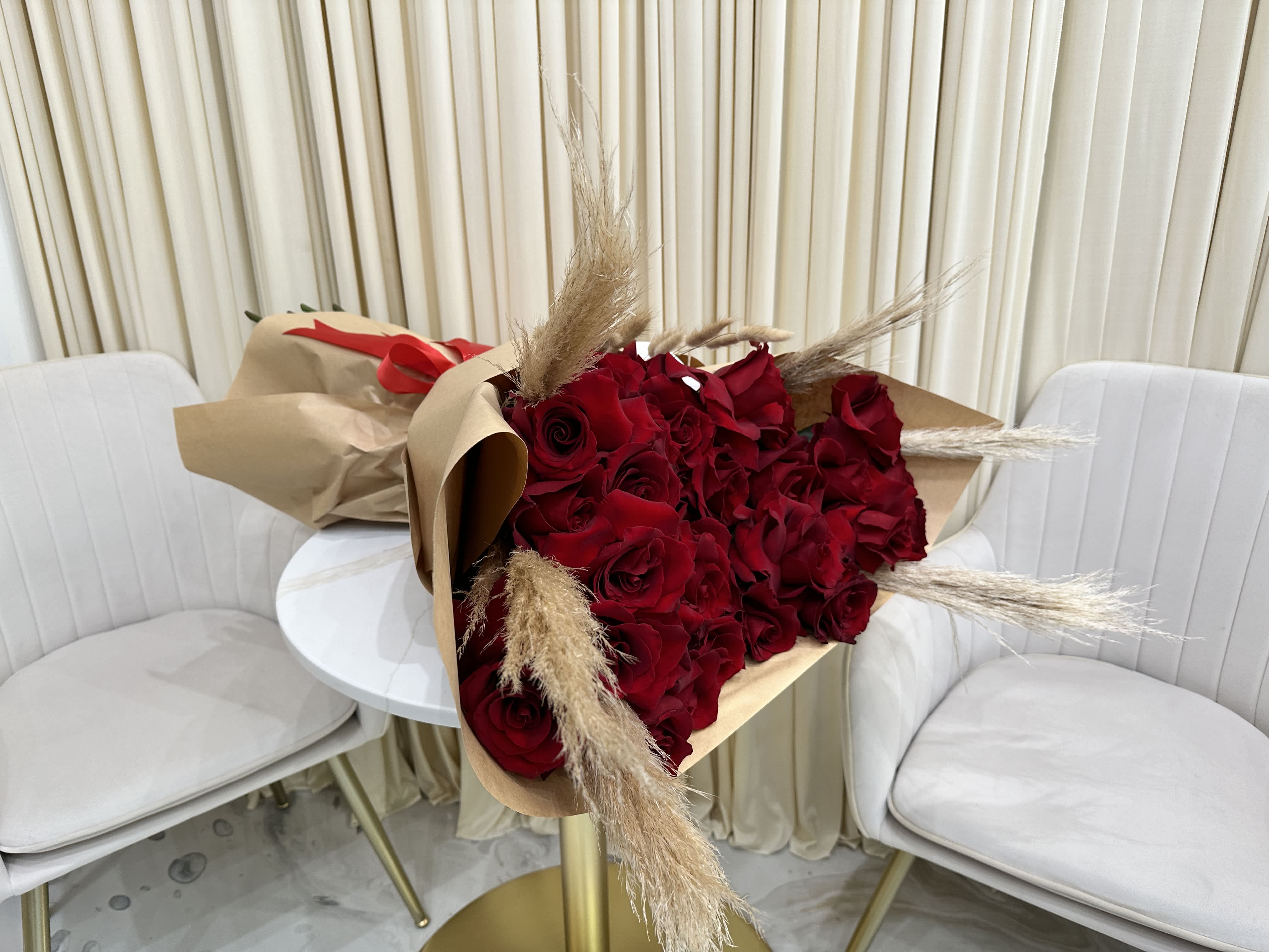 Wild at Heart - Let love bloom with captivating imperfection in this Untamed Passion Red Rose Bouquet. Handpicked for their rich color and natural elegance, these luscious, velvety roses unfurl in various stages of beauty, creating a whimsical cascade of blooms. Imagine the delightful surprise as vibrant reds unveil their intricate layers, whispering stories of untamed passion and raw emotion.  This isn't your typical, perfectly structured bouquet. It's a celebration of nature's artistry, where each rose stands tall, proudly displaying its unique form. Intentionally untethered, the arrangement allows the roses to breathe and showcase their individual charm, creating a breathtaking display of organic beauty.  Perfect for the free spirit, the one who cherishes authenticity and embraces life's imperfections, this bouquet speaks volumes without a single word. It's a declaration of love that's bold, passionate, and refreshingly genuine.