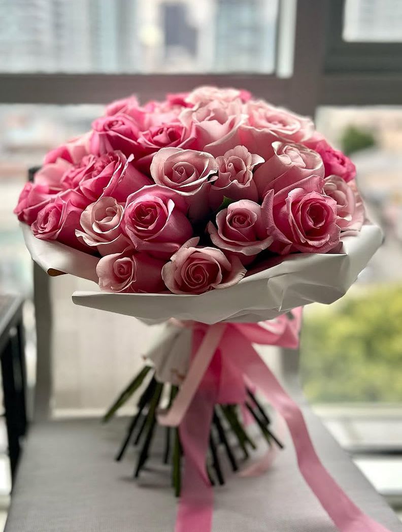 Tickled Pink - This bouquet is all about that dreamy, soft pink vibe! A whole bunch of gorgeous, velvety roses wrapped up in clean white paper with a pop of matching pink ribbon—seriously classy but super sweet. It’s the kinda bouquet that screams “You’re amazing” without even trying too hard. Perfect for making someone’s day extra special, whether it’s a date, birthday, or just because you’re feeling the love! 